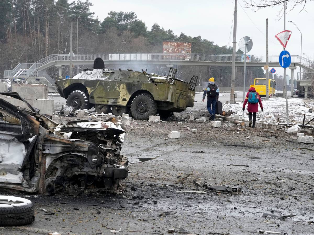 Warum greift Russland die Ukraine an? Menschen laufen am 1. März vor Kiew an völlig zerstörten Militärfahrzeugen vorbei. Seit fast einer Woche herrscht Krieg in der Ukraine. Warum eigentlich?