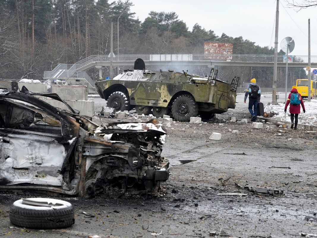 Warum greift Russland die Ukraine an? Menschen laufen am 1. März vor Kiew an völlig zerstörten Militärfahrzeugen vorbei. Seit fast einer Woche herrscht Krieg in der Ukraine. Warum eigentlich?
