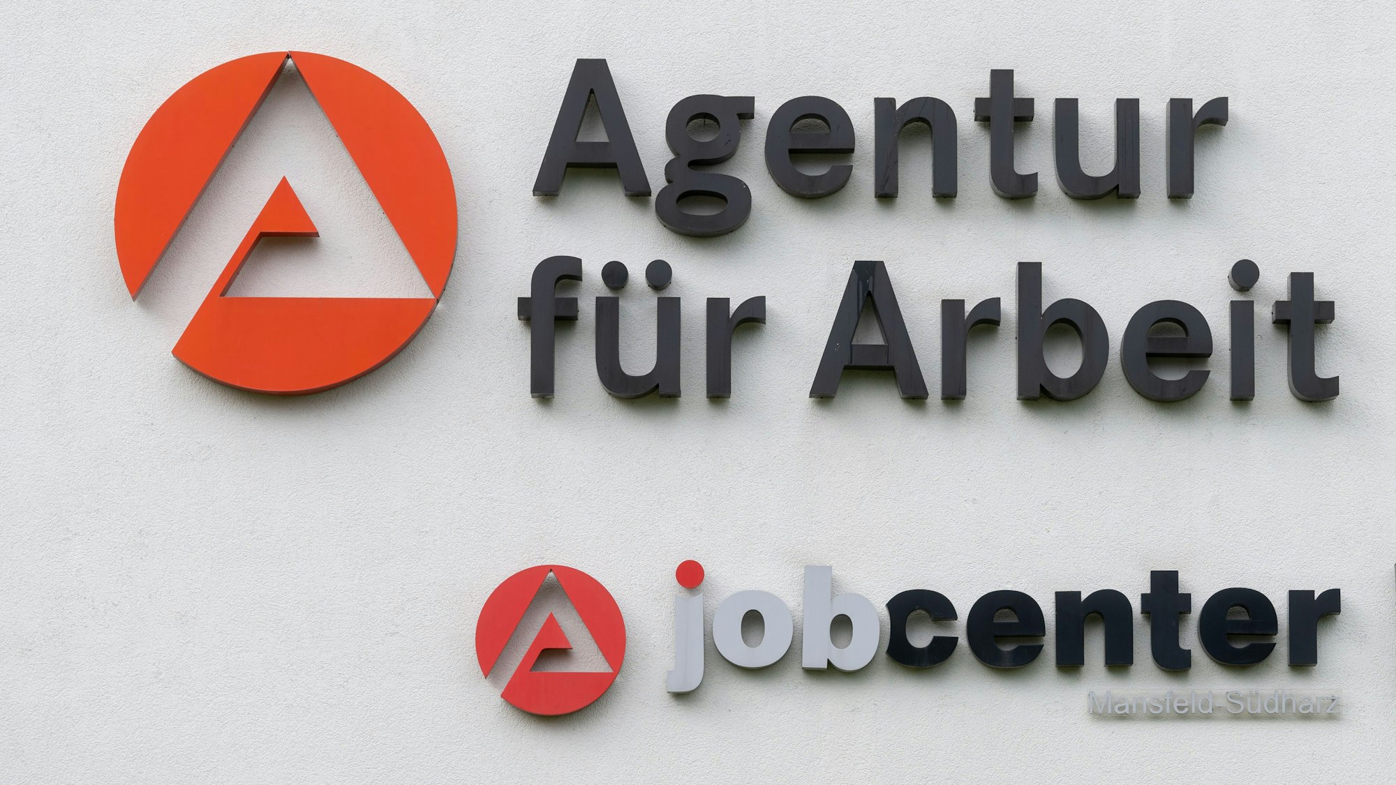 Das Logo der Agentur für Arbeit und des Jobcenters ist an dem Gebäudekomplex der Behörde in Sangerhausen zu sehen.