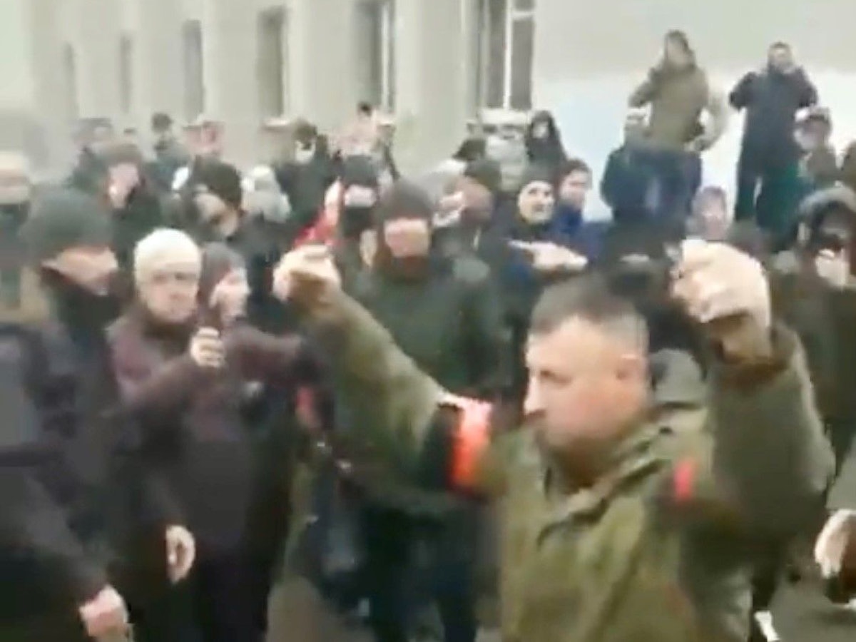 Der Ausschnitt des Twitter-Videos zeigt eine russische Delegation in Konotop (Oblast Sumy), die dem Stadtrat ihre Kapitulationsbedingungen diktierten. Sie verließen anschließend die Verhandlungen mit erhobenen Händen, wurden von den Menschen mit „Schande“ beschimpft.