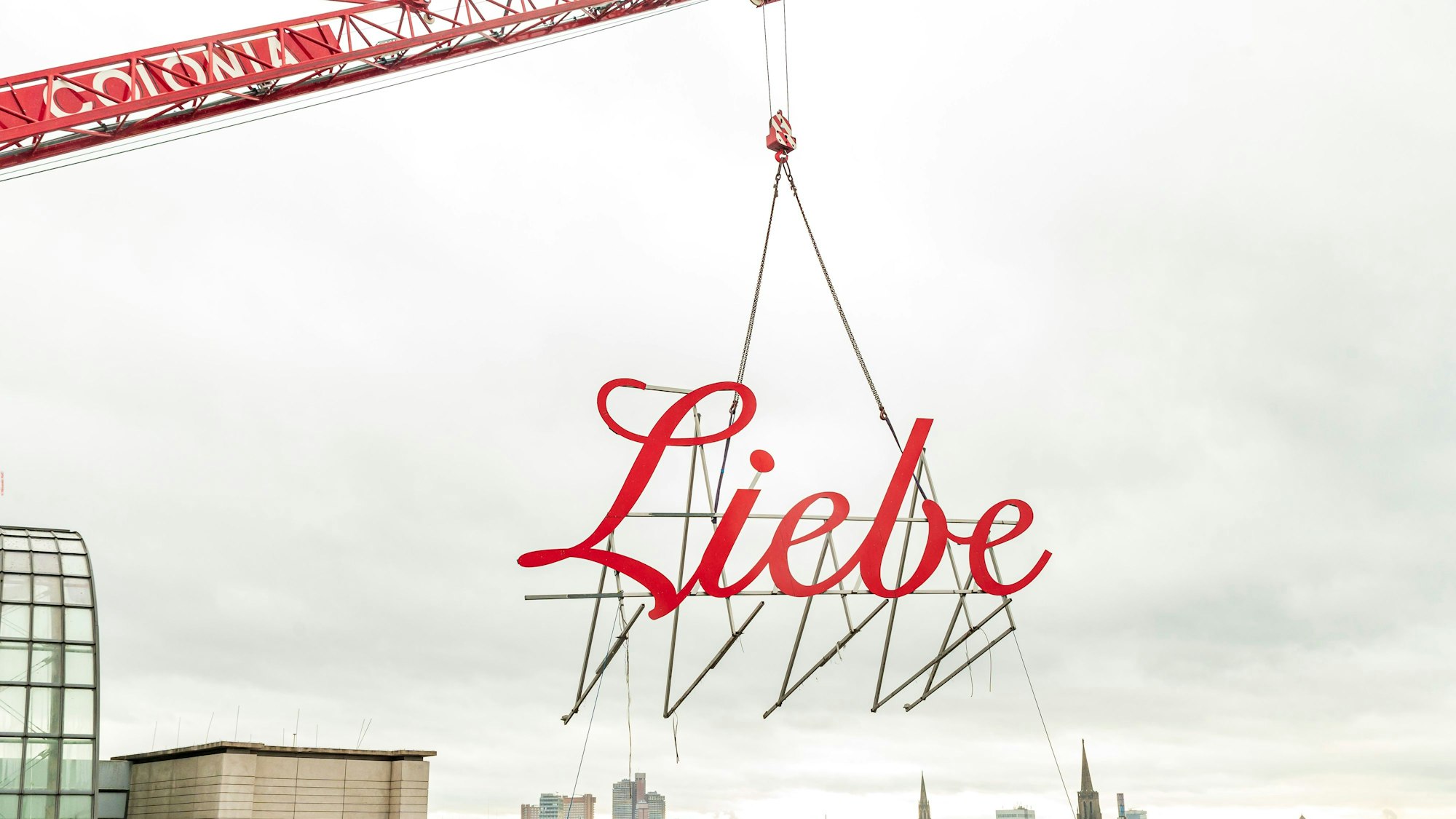 Schriftzug Liebe wird mit einem Kran vom Gebäude geholt.
