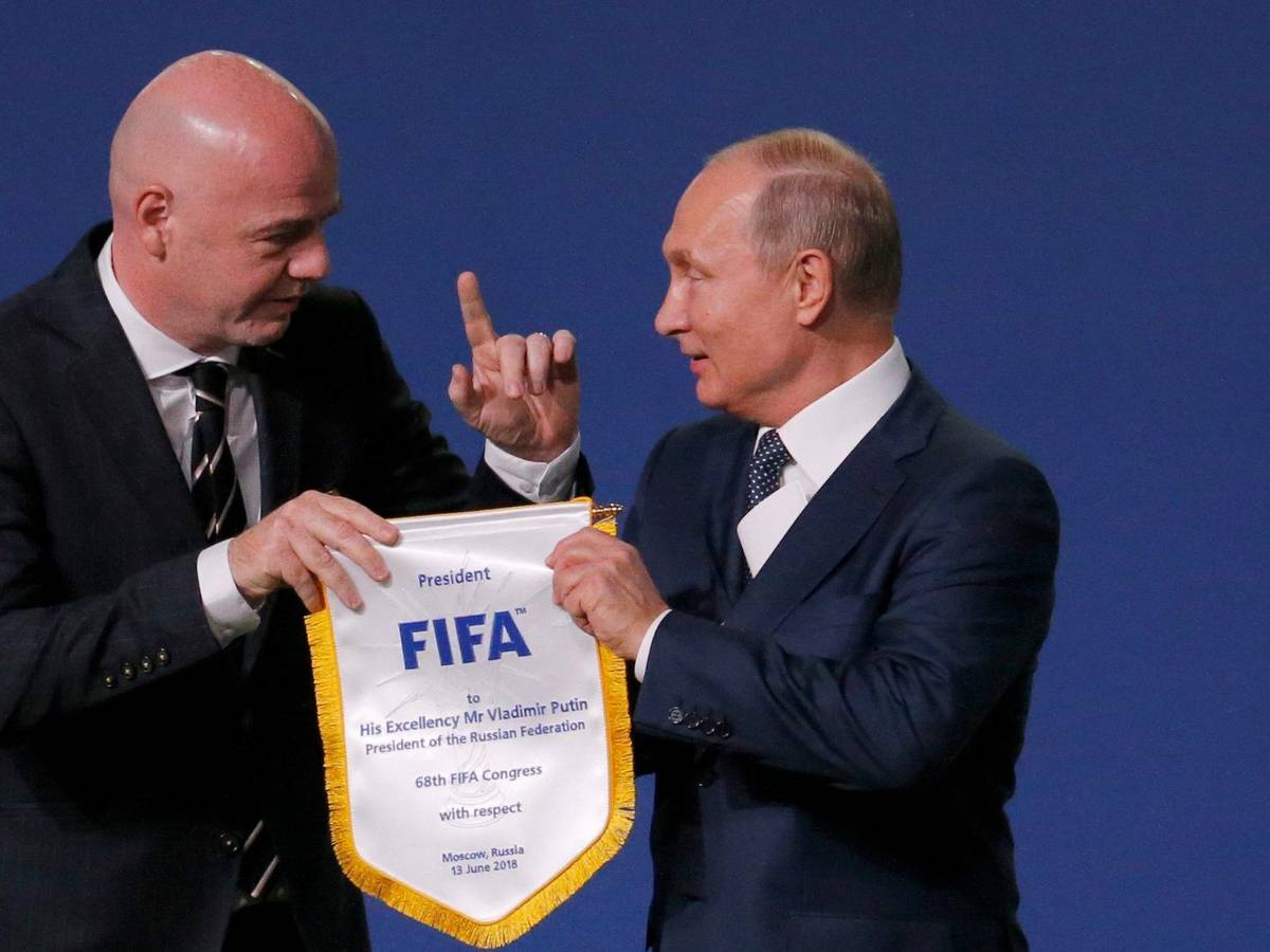 Gianni Infantino übergibt Wladimir Putin einen Wimpel der FIFA.