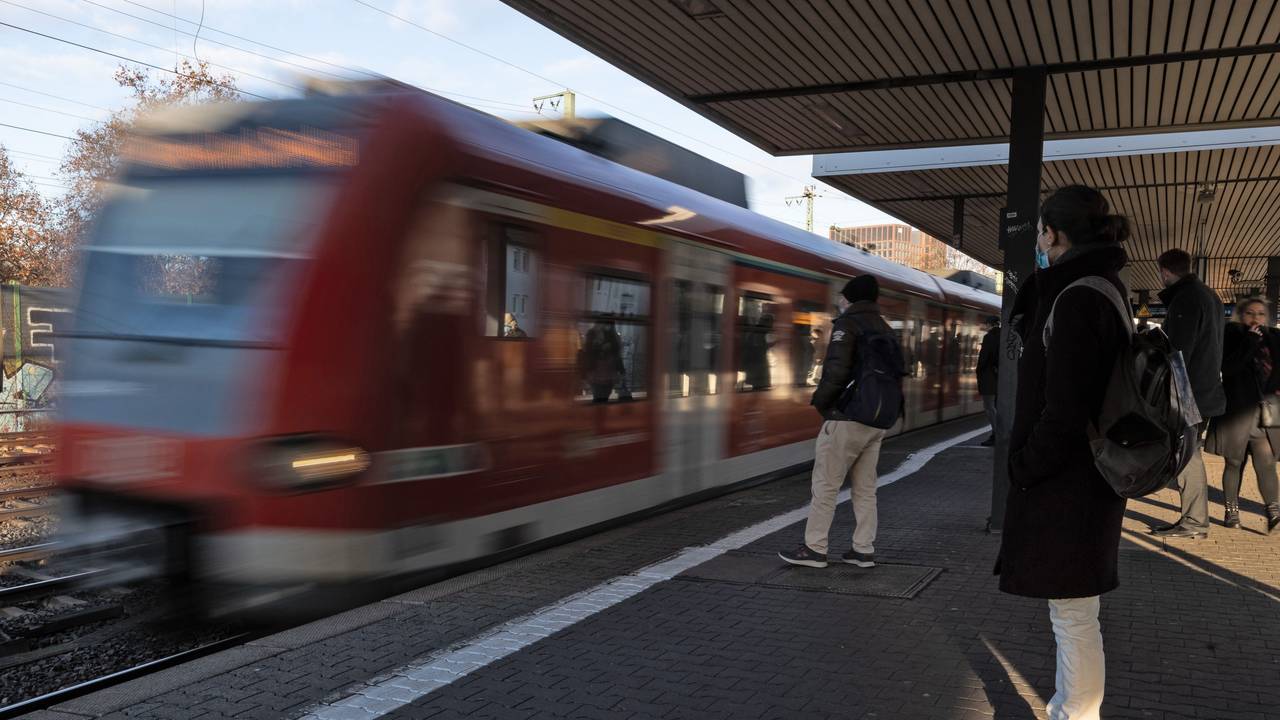 Fahrgäste warten auf den Einstieg, während eine S-Bahn einfährt.