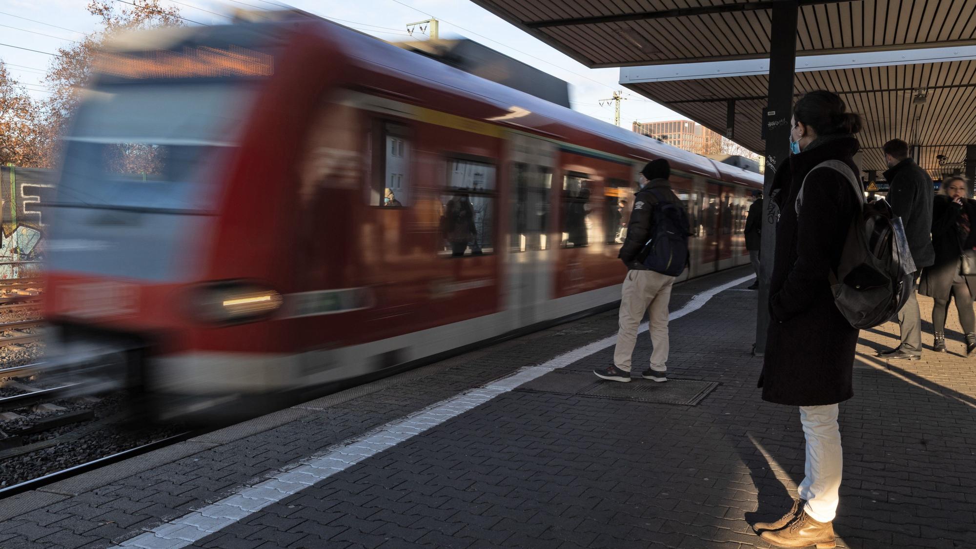 Fahrgäste warten auf den Einstieg, während eine S-Bahn einfährt.