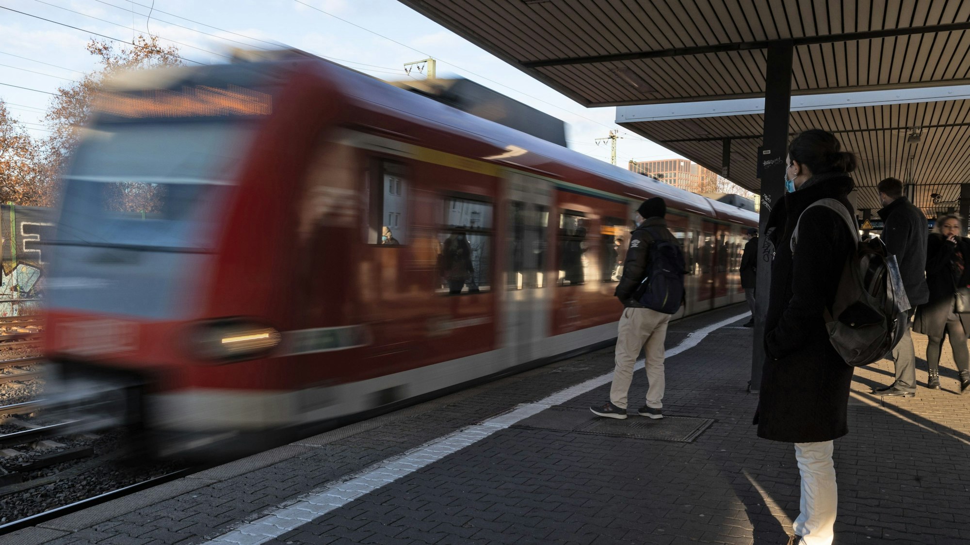 Fahrgäste warten auf den Einstieg, während eine S-Bahn einfährt.
