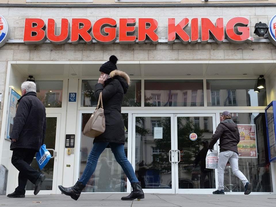 Menschen gehen an Filiale von Burger King vorbei.