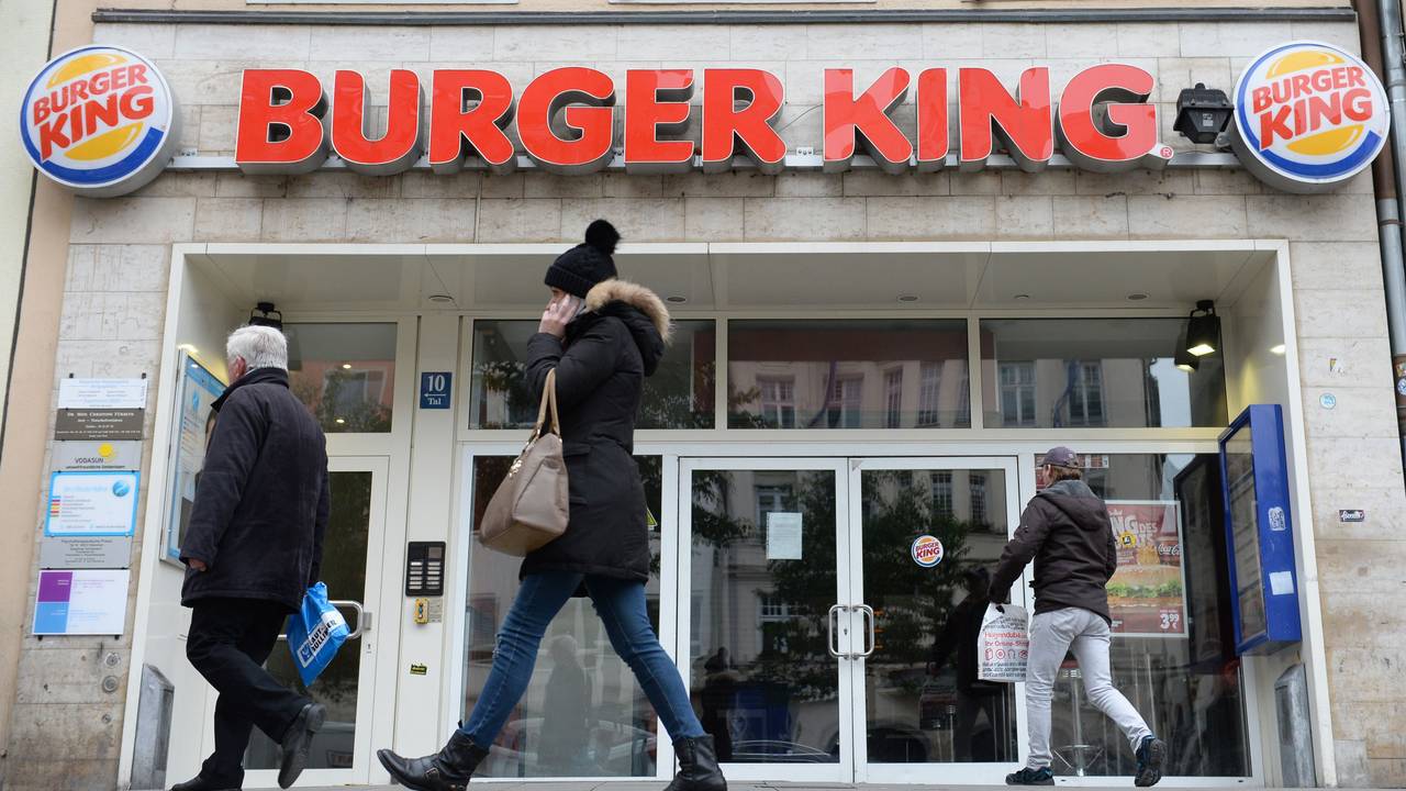 Menschen gehen an Filiale von Burger King vorbei.