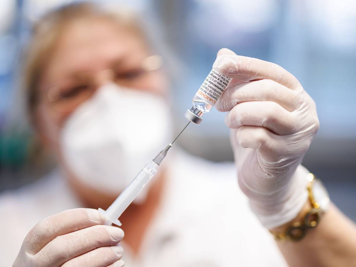 Eine Krankenschwester zieht im Impfzentrum Freising den Impfstoff Nuvaxovid vom Hersteller Novavax auf eine Spritze auf.