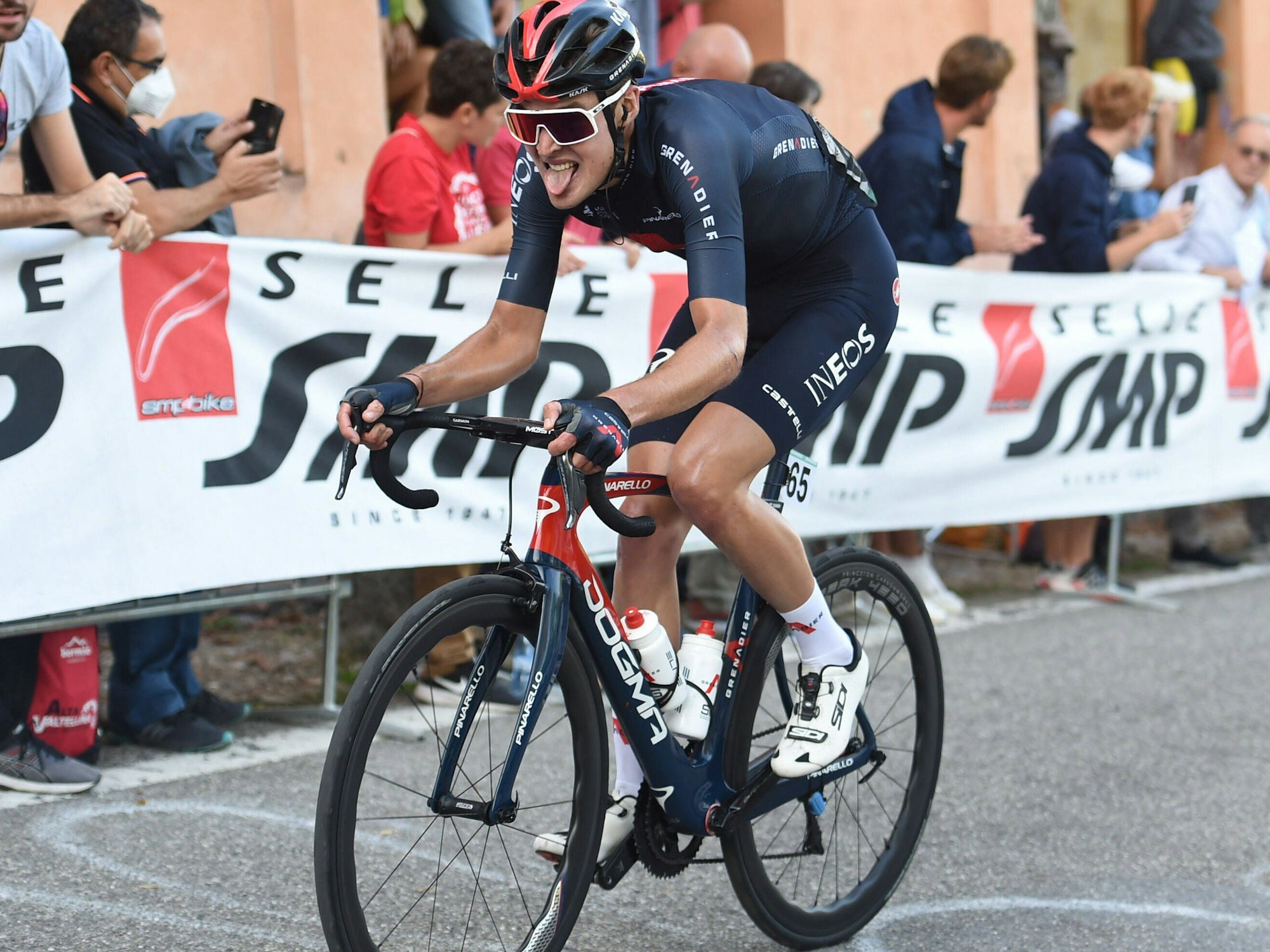 Pawel Siwakow mit herausgestrecker Zunge auf de Rennrad.