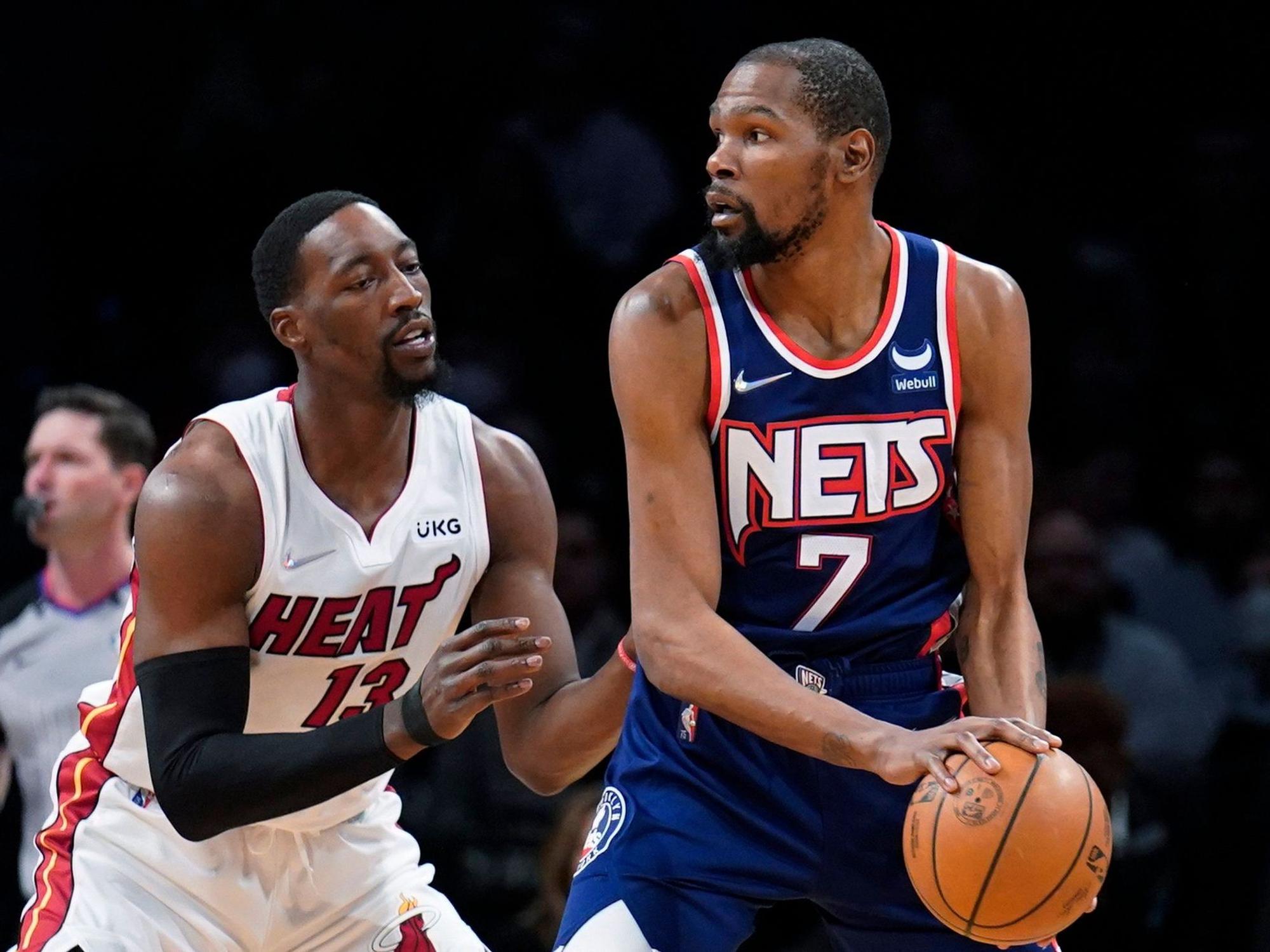 Kevin Durant (r) von den Brooklyn Nets versucht, den Ball zu passen, während Bam Adebayo von den Miami Heat verteidigt.