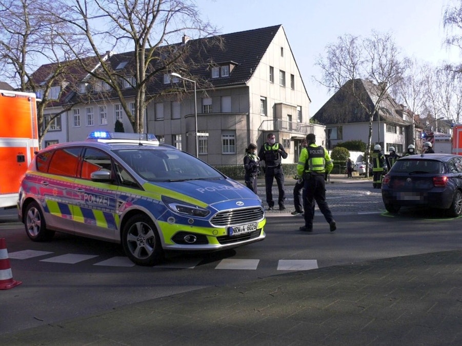 Polizisten stehen nach einem Unfall auf einer Straße in Köln.
