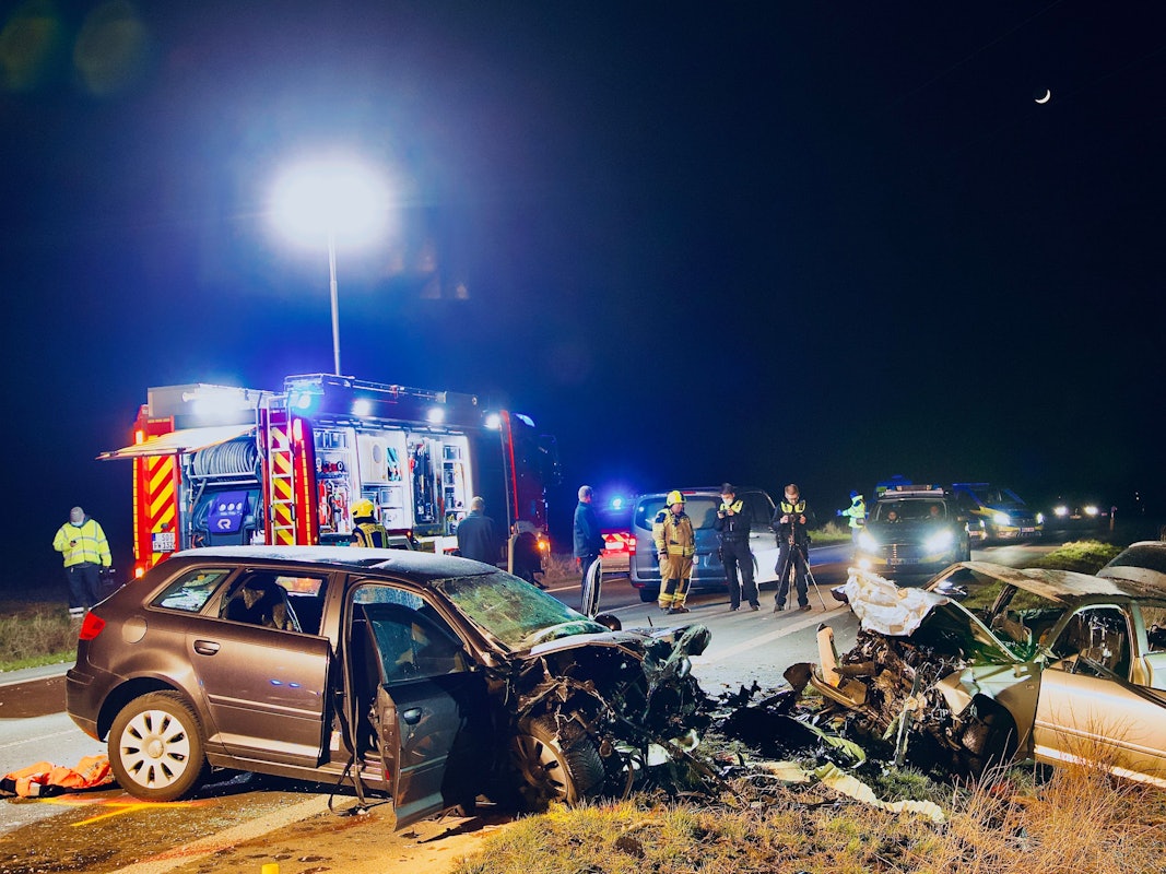 Einsatzkräfte der Polizei und Feuerwehr stehen an der Unfallstelle. Bei einem Frontalzusammenstoß in Unna sind am Samstag (5. März 2022) drei Menschen gestorben.