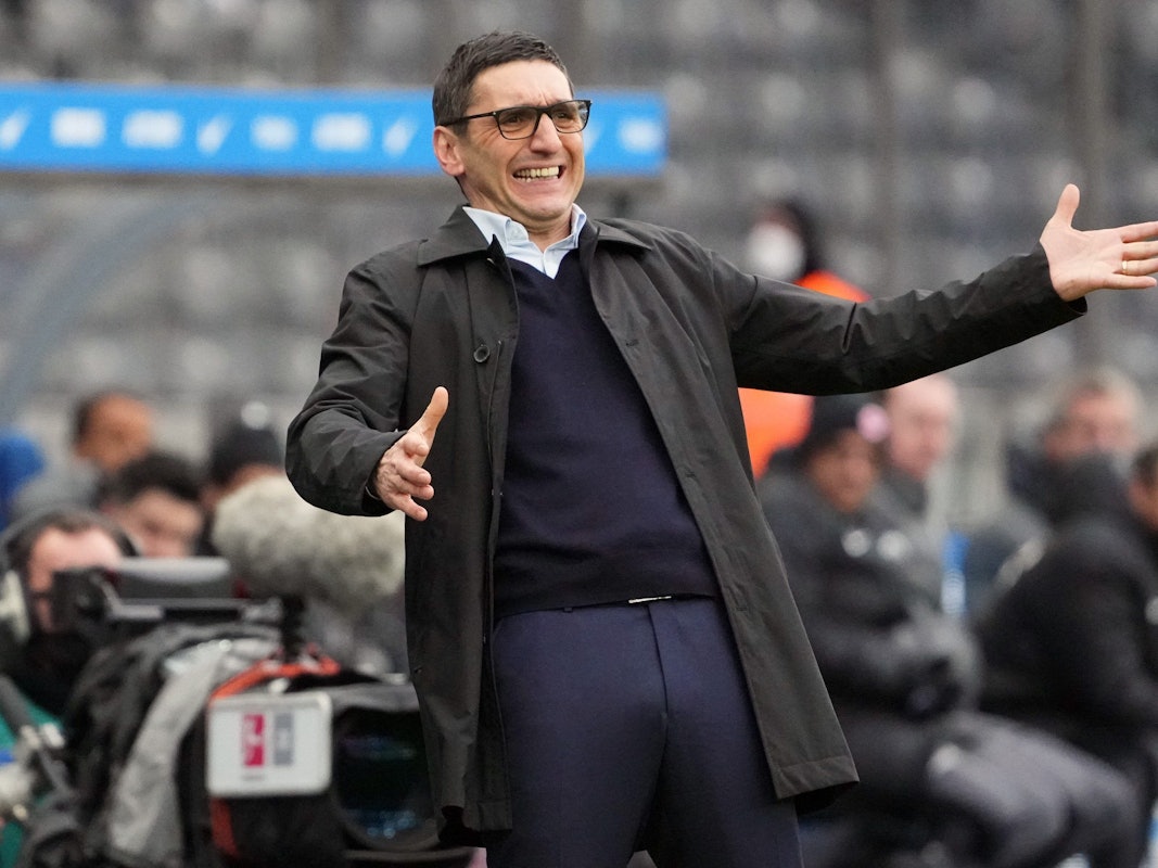Herthas Cheftrainer Tayfun Korkut breitet am Spielfeldrand die Arme aus.
