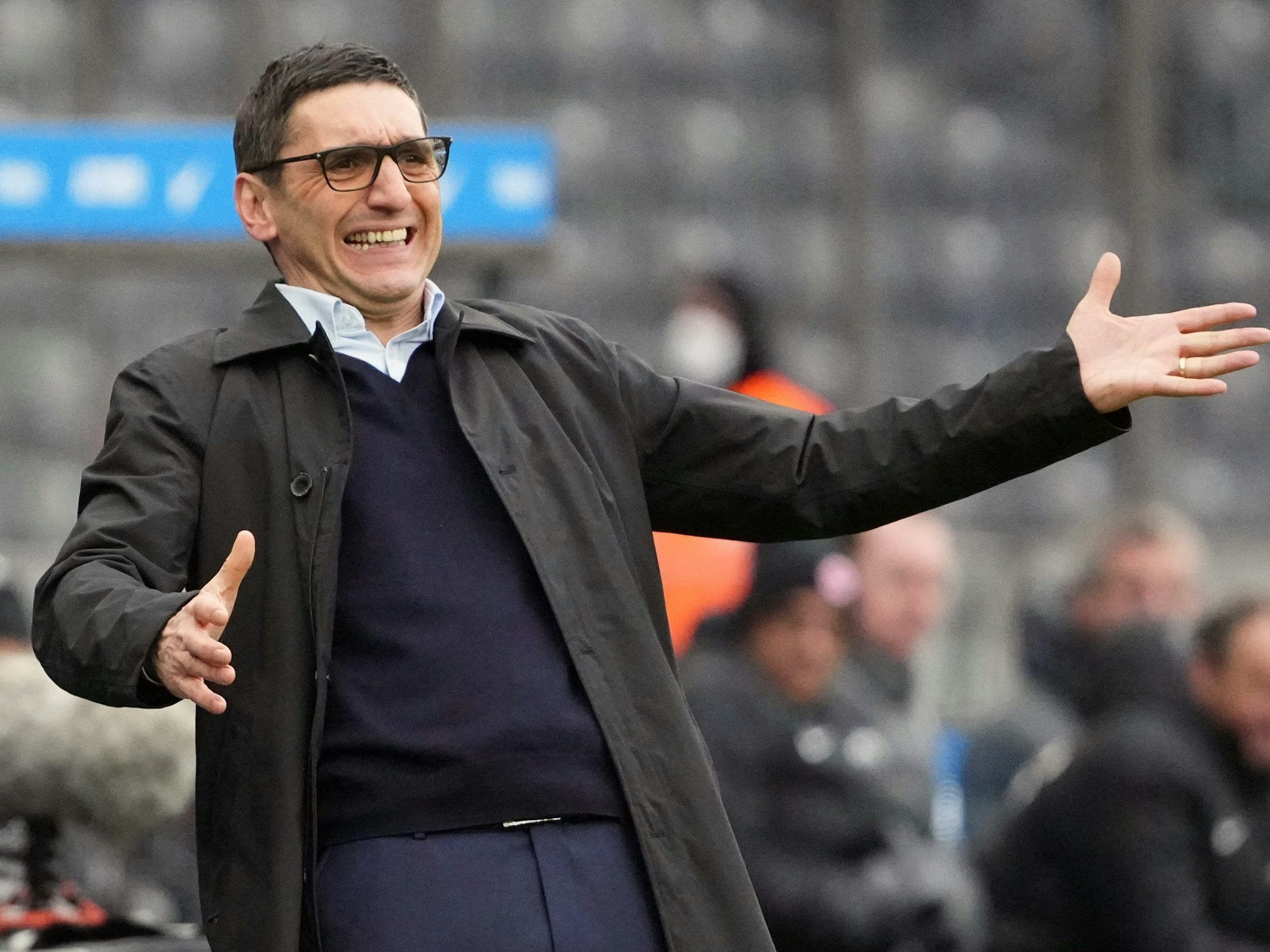 Herthas Cheftrainer Tayfun Korkut breitet am Spielfeldrand die Arme aus.