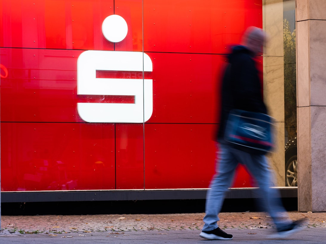 Passanten laufen an einer Filiale der Sparkasse vorbei.