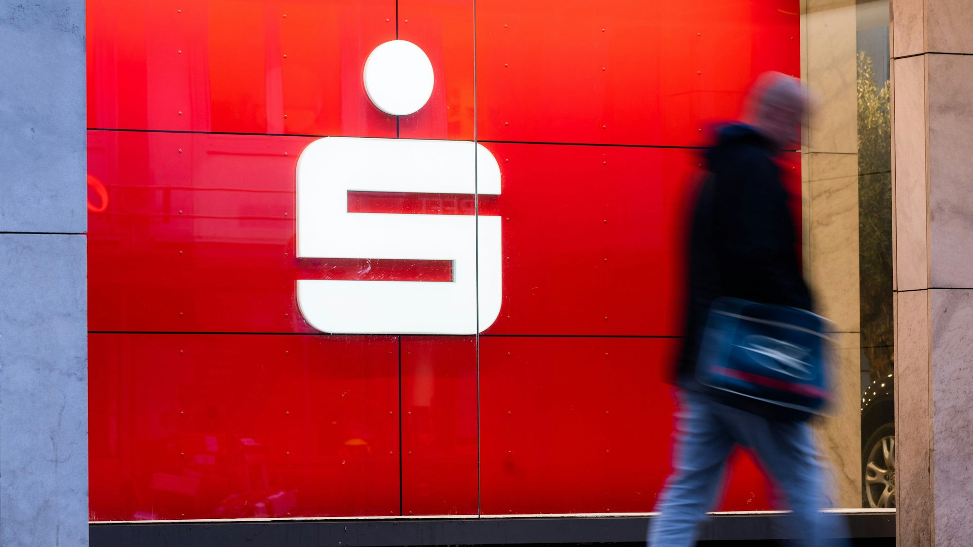 Passanten laufen an einer Filiale der Sparkasse vorbei.