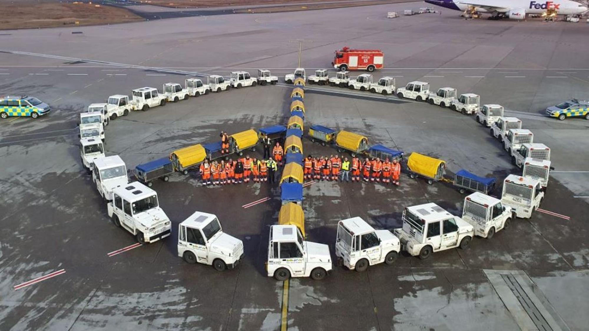 Peace-Zeichen für die Ukraine, geformt aus Fahrzeugen, am Flughafen Köln/Bonn.