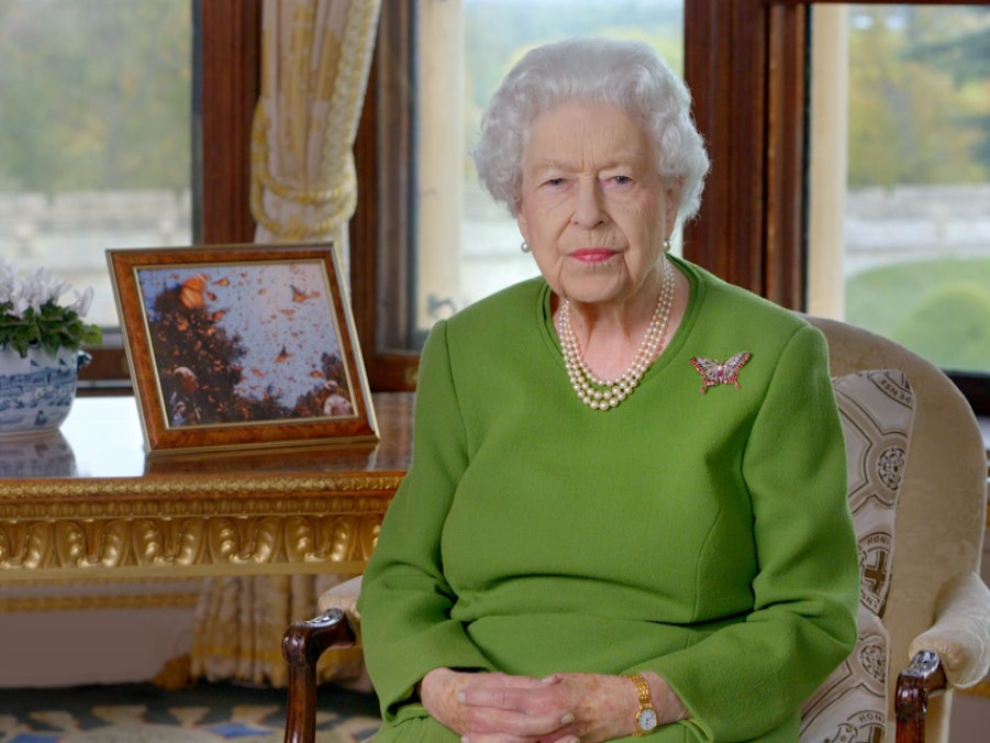 Königin Elizabeth II.posiert auf einem Stuhl für ein Foto.