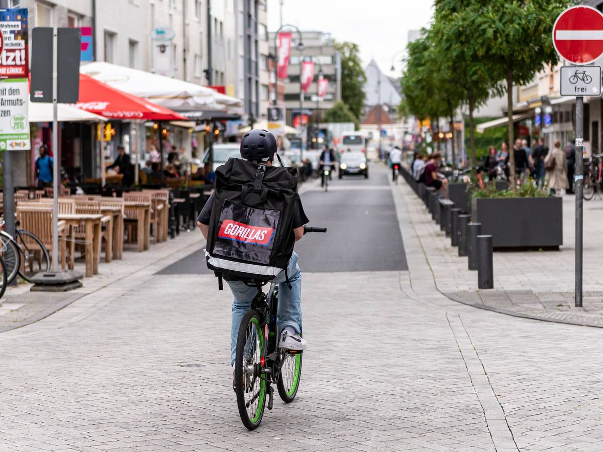 Ein Fahrer des Lieferdienstes Gorillas ist am 20. August 2021 in der Kölner Südstadt unterwegs. In diesem Fall entgegengesetzt der Einbahnstraße, aber das Schild weist darauf hin, dass es erlaubt ist.