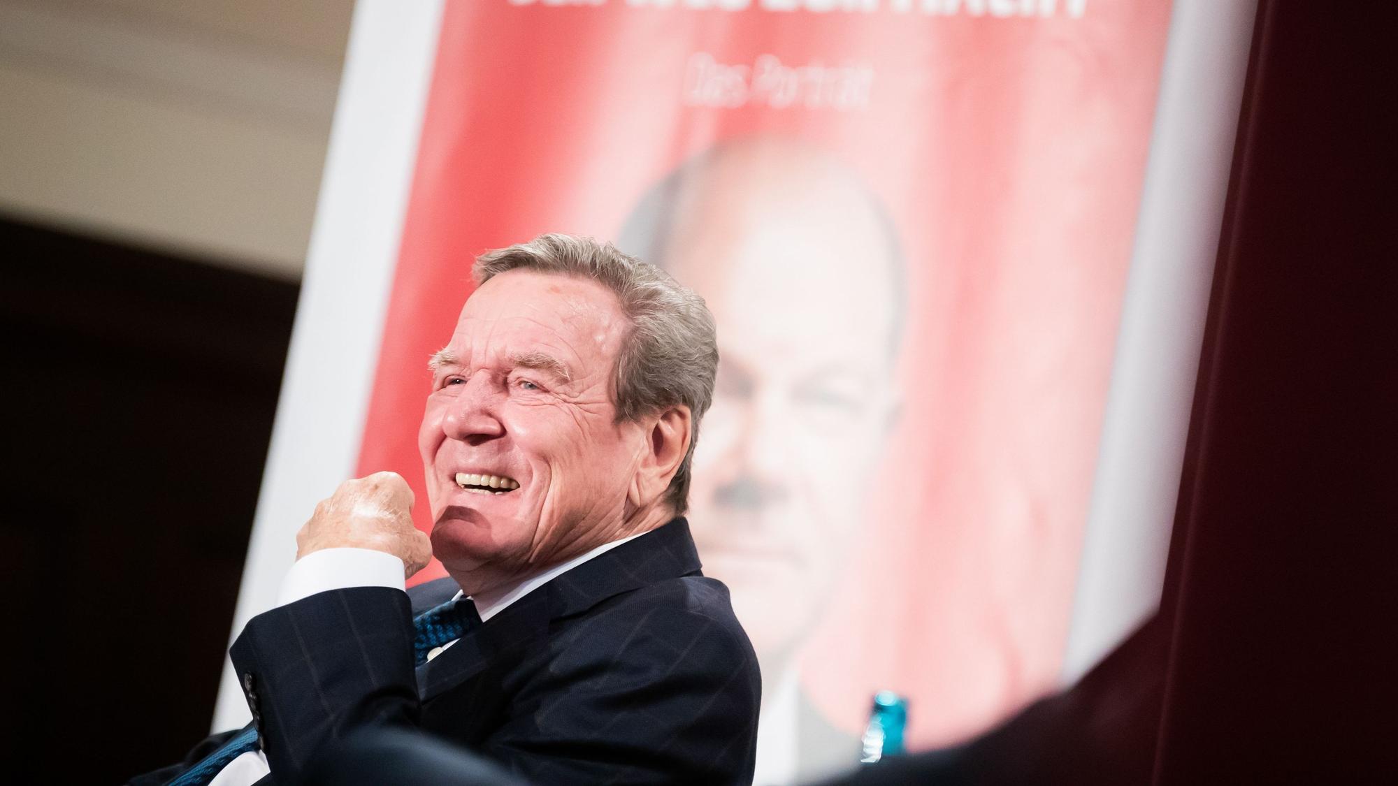 Gegen den früheren Bundeskanzler Gerhard Schröder (SPD, hier Anfang Dezember 2021 bei der Vorstellung der Biografie über Olaf Scholz) ist Strafanzeige wegen Verbrechens gegen die Menschlichkeit gestellt worden.
