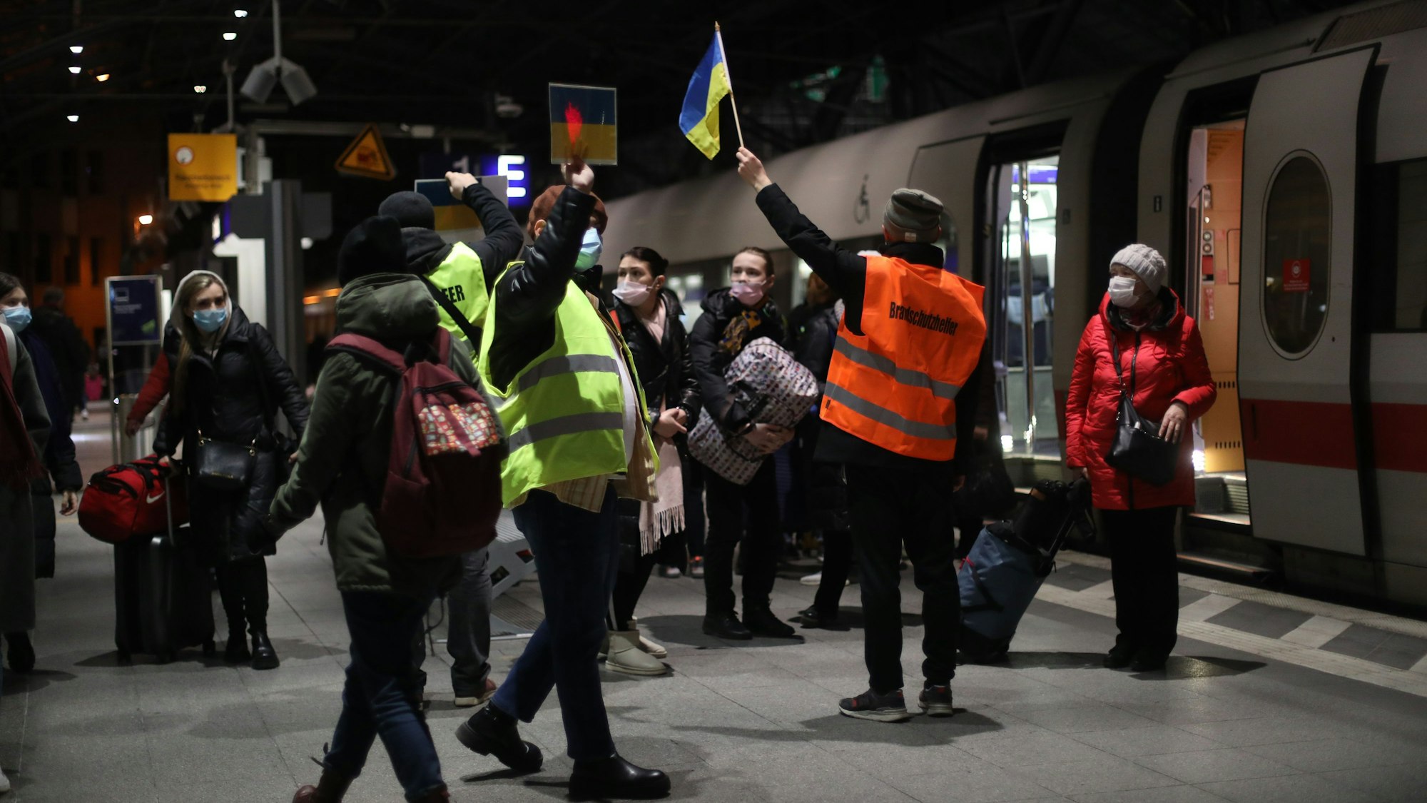 Ersthelfer empfangen am Kölner Hauptbahnhof Flüchtlinge aus der Ukraine.