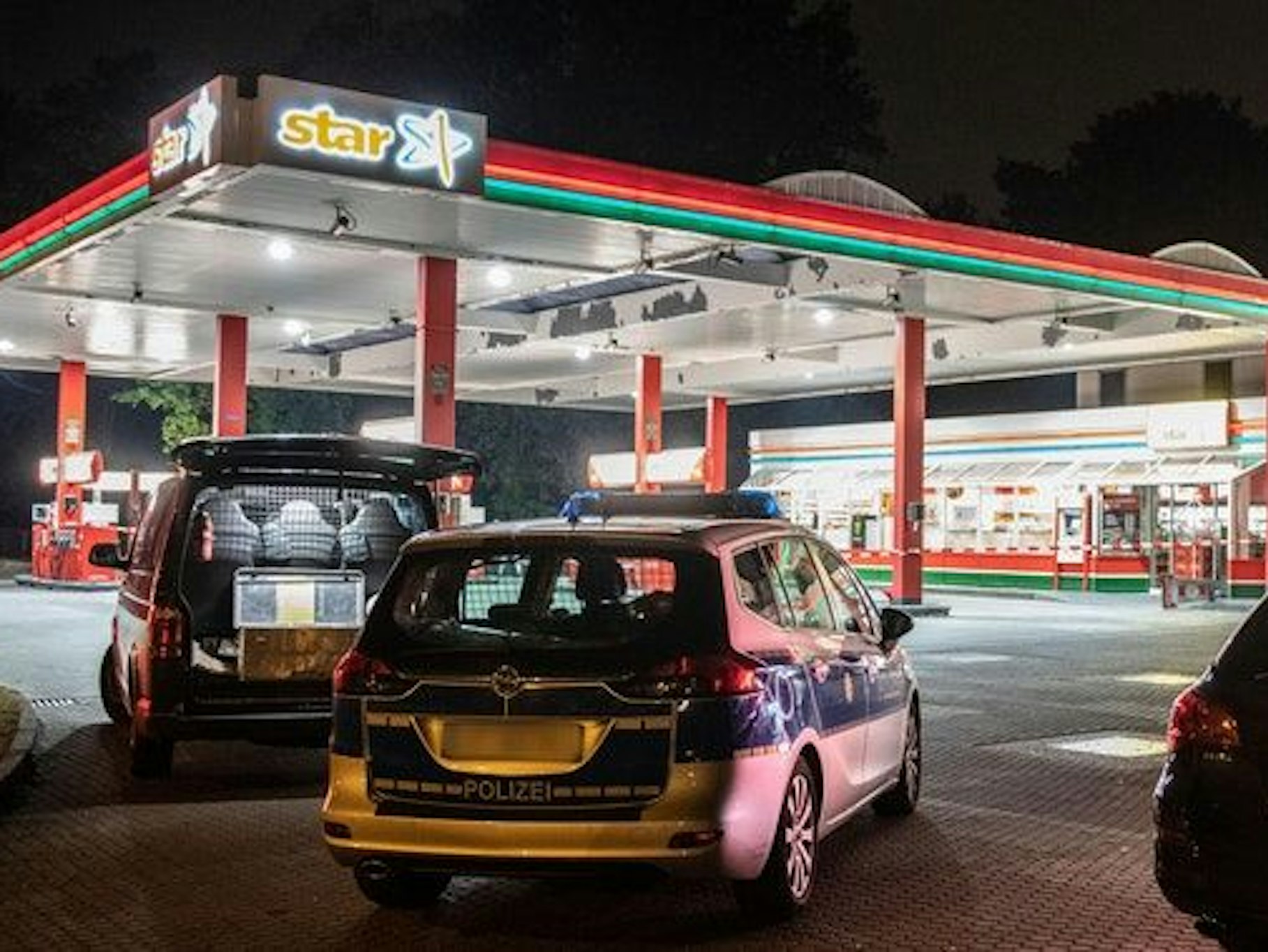 Polizeiwagen an einer Tankstelle.
