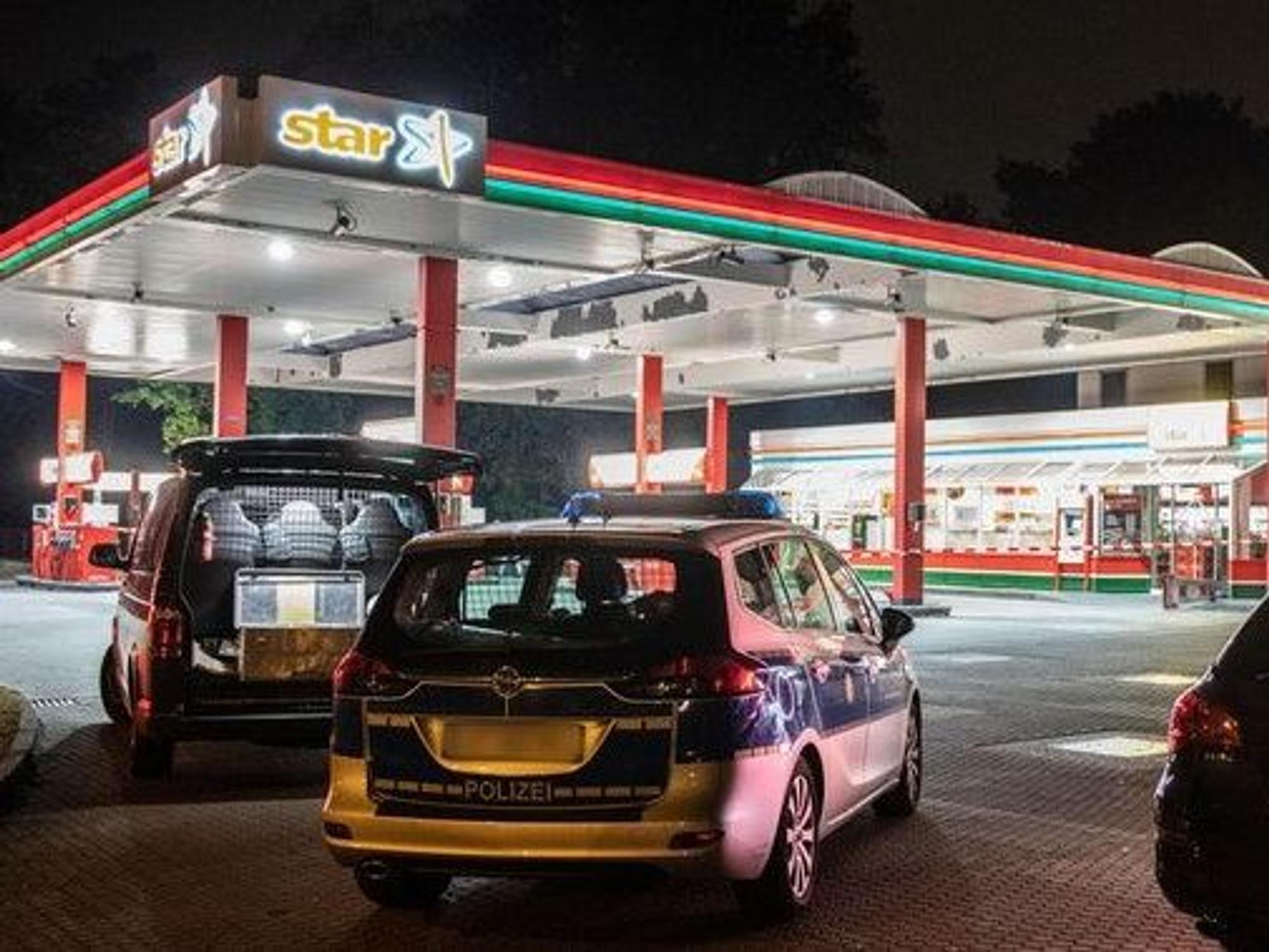 Polizeiwagen an einer Tankstelle.