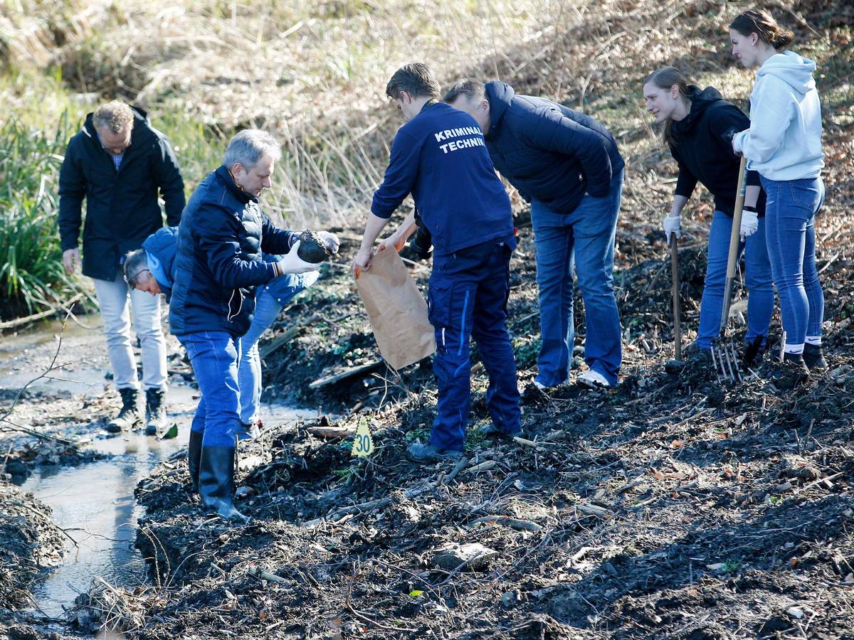 Kriminaltechniker der Polizei bei der Arbeit an einem Bach.