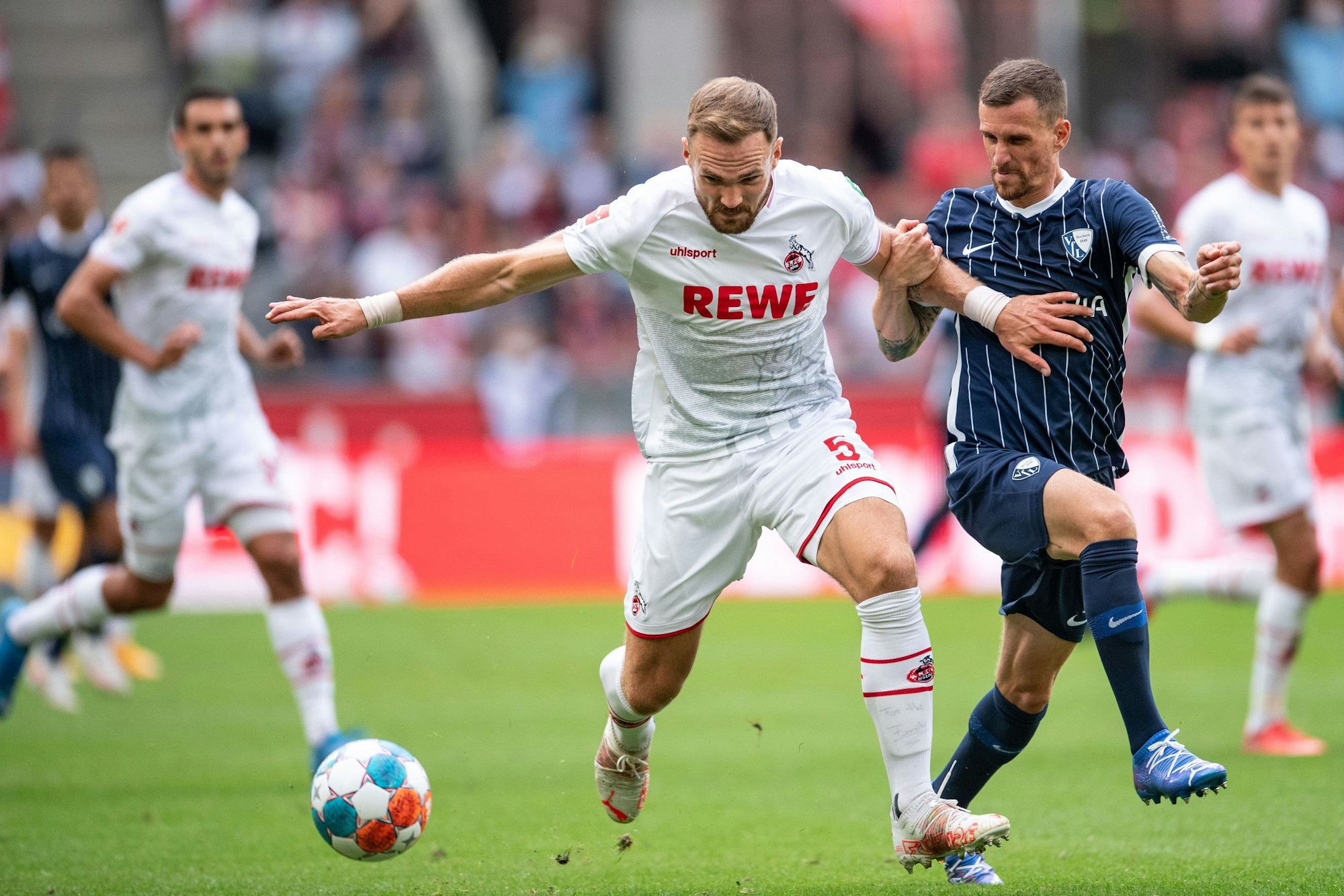 Kölns Rafael Czichos und Bochums Simon Zoller (r) kämpfen um den Ball.