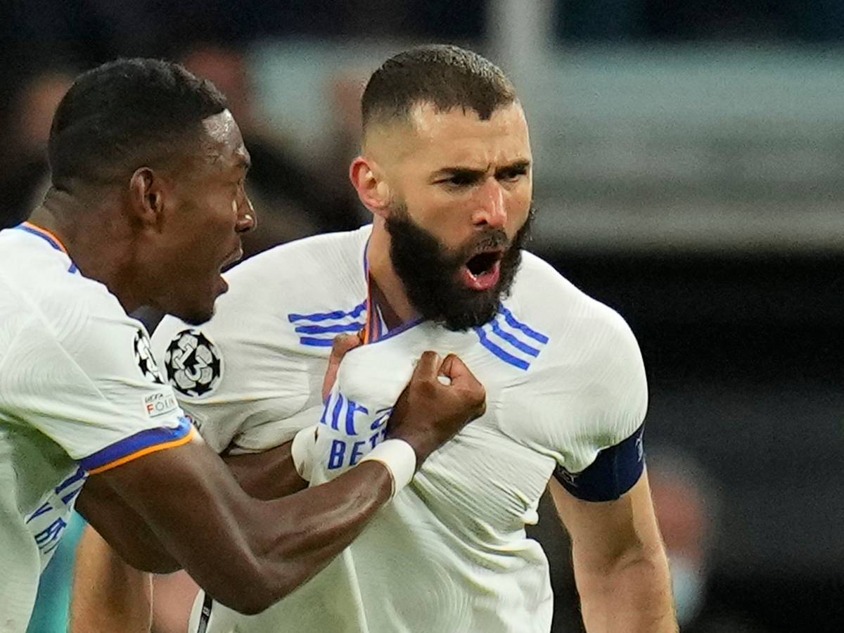 Real Madrid's David Alaba celebrates with Karim Benzema, right, who scored his side's first goal during the Champions League, round of 16, second leg soccer match between Real Madrid and Paris Saint-Germain at the Santiago Bernabeu stadium in Madrid, Spain, Wednesday, March 9, 2022. (AP Photo/Manu Fernandez)