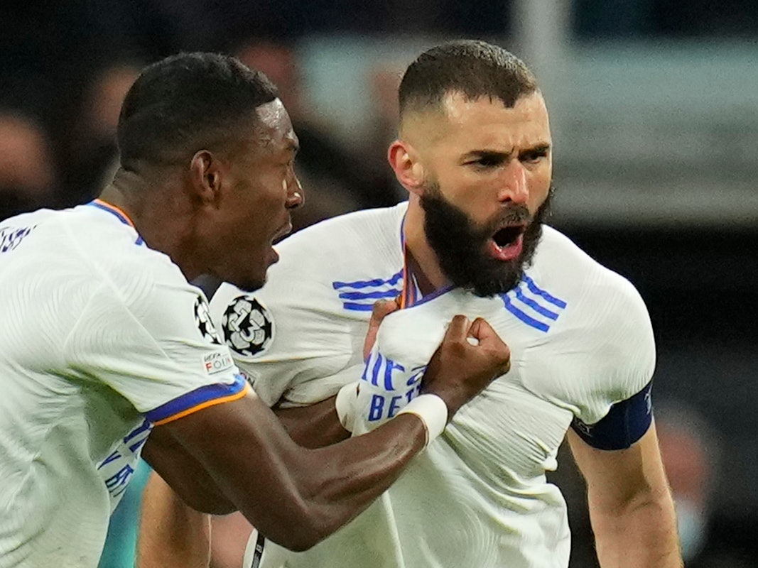 Real Madrid's David Alaba celebrates with Karim Benzema, right, who scored his side's first goal during the Champions League, round of 16, second leg soccer match between Real Madrid and Paris Saint-Germain at the Santiago Bernabeu stadium in Madrid, Spain, Wednesday, March 9, 2022. (AP Photo/Manu Fernandez)