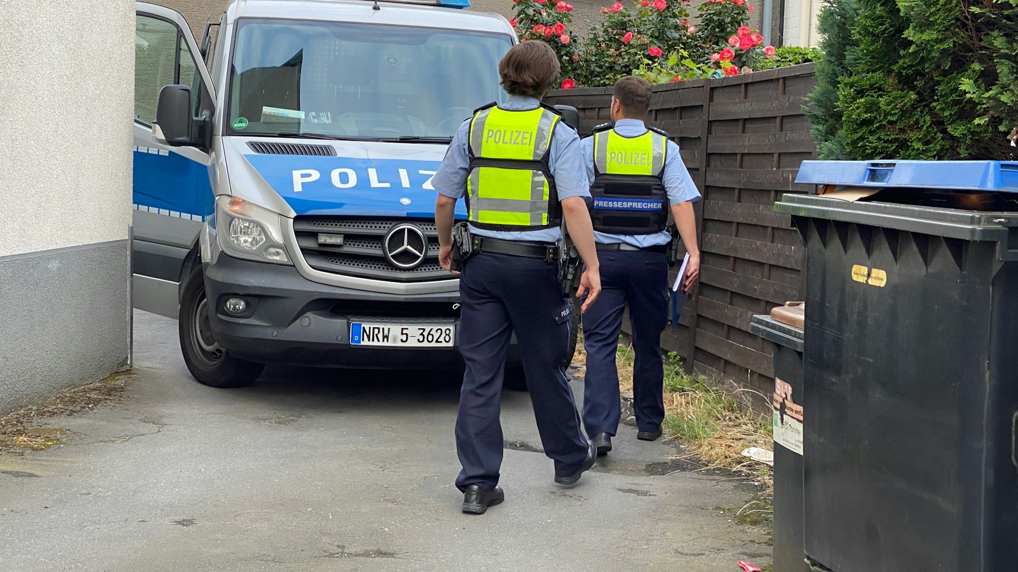 Polizisten gehen bei einer Razzia in ein Wohnhaus.