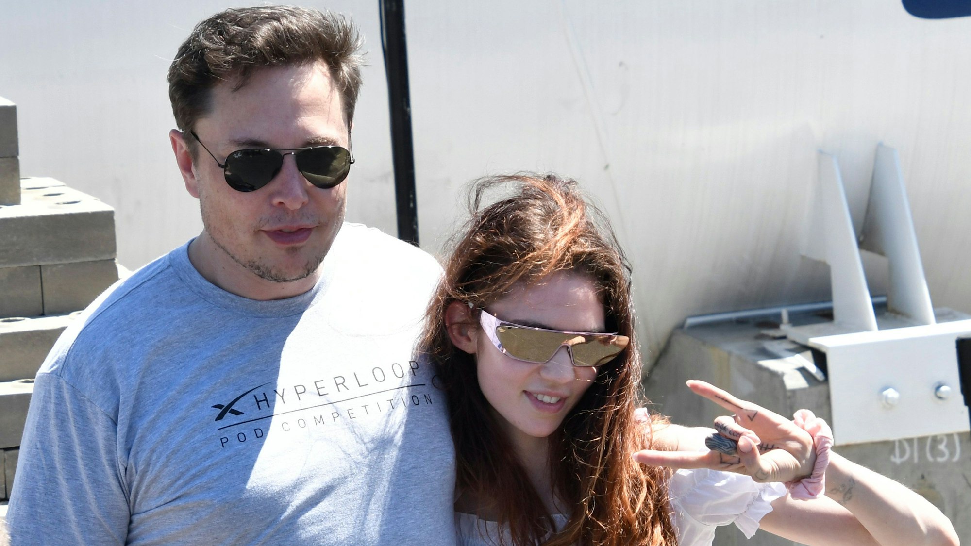 22.07.2018, USA, Hawthorne: Elon Musk, Vorstandsvorsitzender von Space Exploration Technologies Corp. (SpaceX), steht bei einem Hyperloop-Wettbewerb mit seiner Freundin, der kanadischen Sängerin Grimes, zusammen.