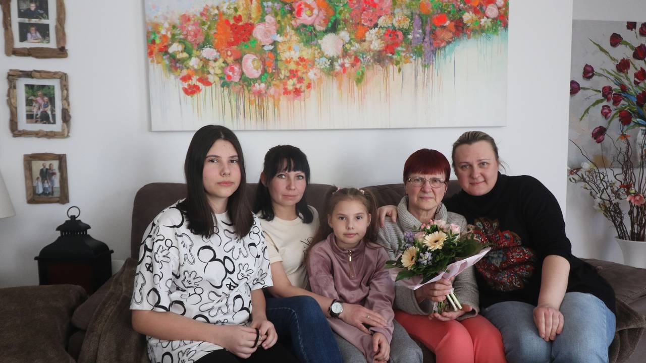 Eine ukrainische Familie sitzt auf einem Sessel und schaut in die Kamera.