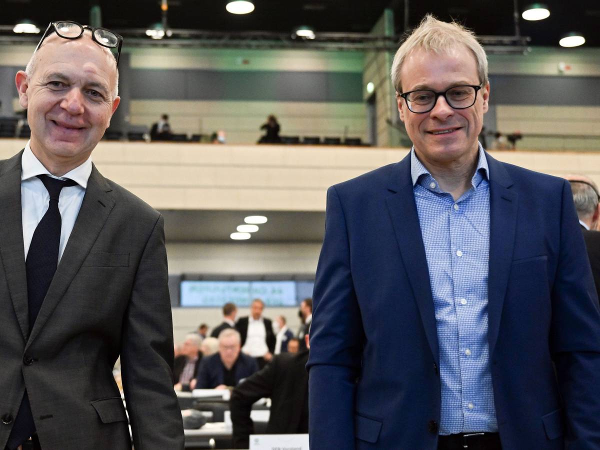 Die beiden Kandidaten für das Amt des DFB-Präsidenten, Bernd Neuendorf (l) und Peter Peters stehen vor der Versammlung zusammen.
