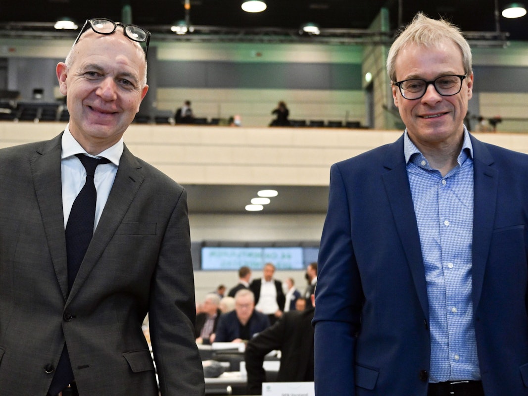 Die beiden Kandidaten für das Amt des DFB-Präsidenten, Bernd Neuendorf (l) und Peter Peters stehen vor der Versammlung zusammen.