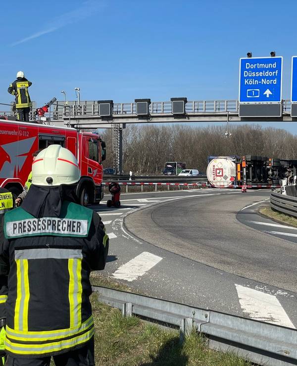 Ein Lkw liegt auf der Seite, davor steht eine Feuerwehrfahrzeug.
