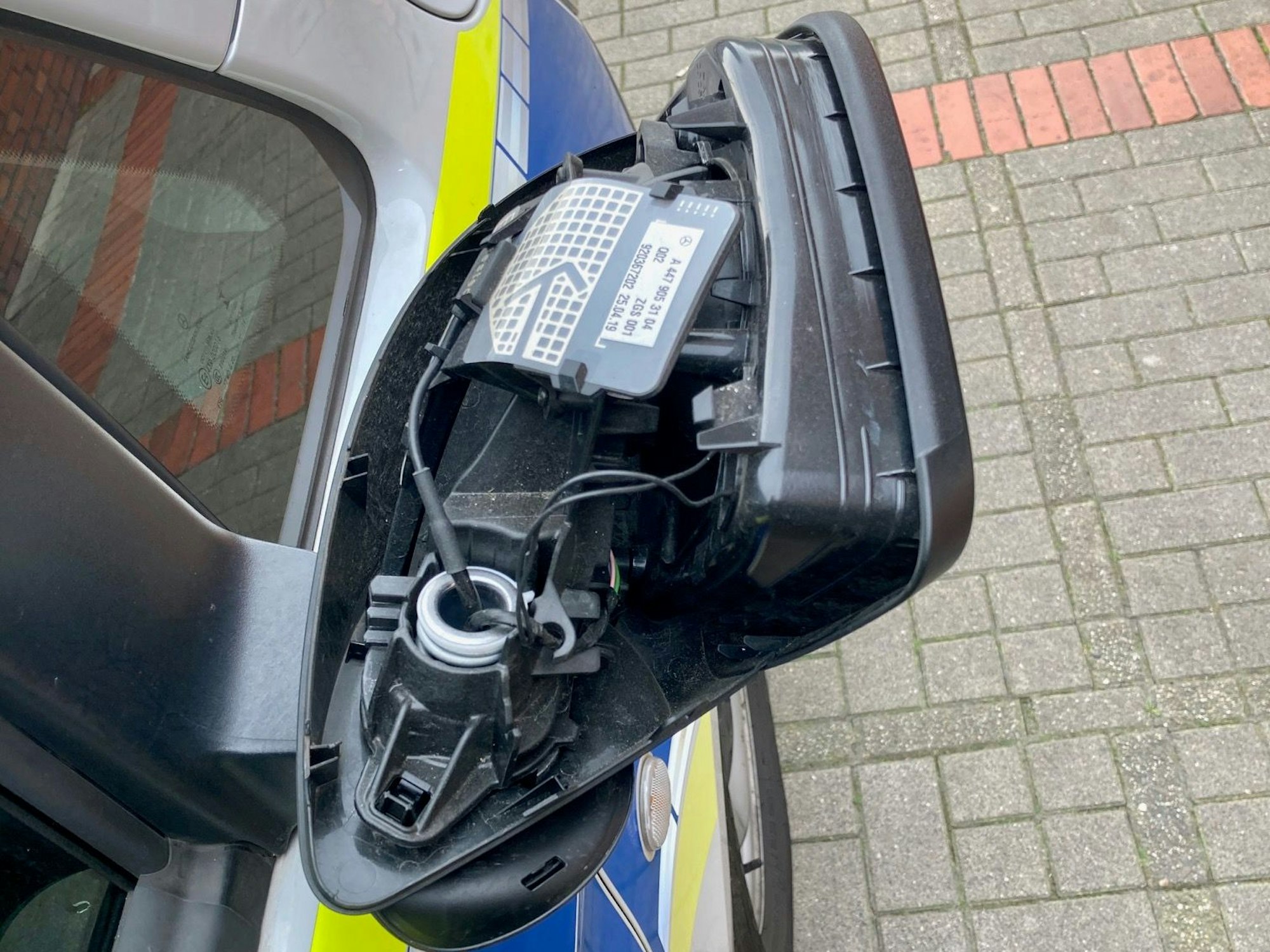 Beschädigter Außenspiegel eines Polizeiautos.