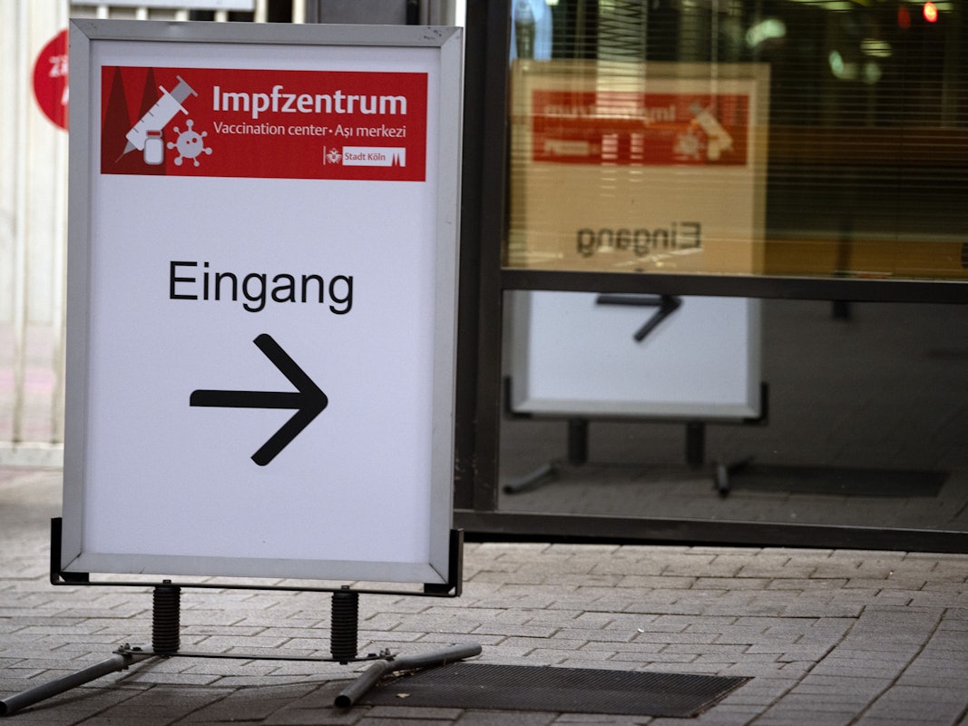 Schild weist Eingang zu einem Impfzentrum in Köln.