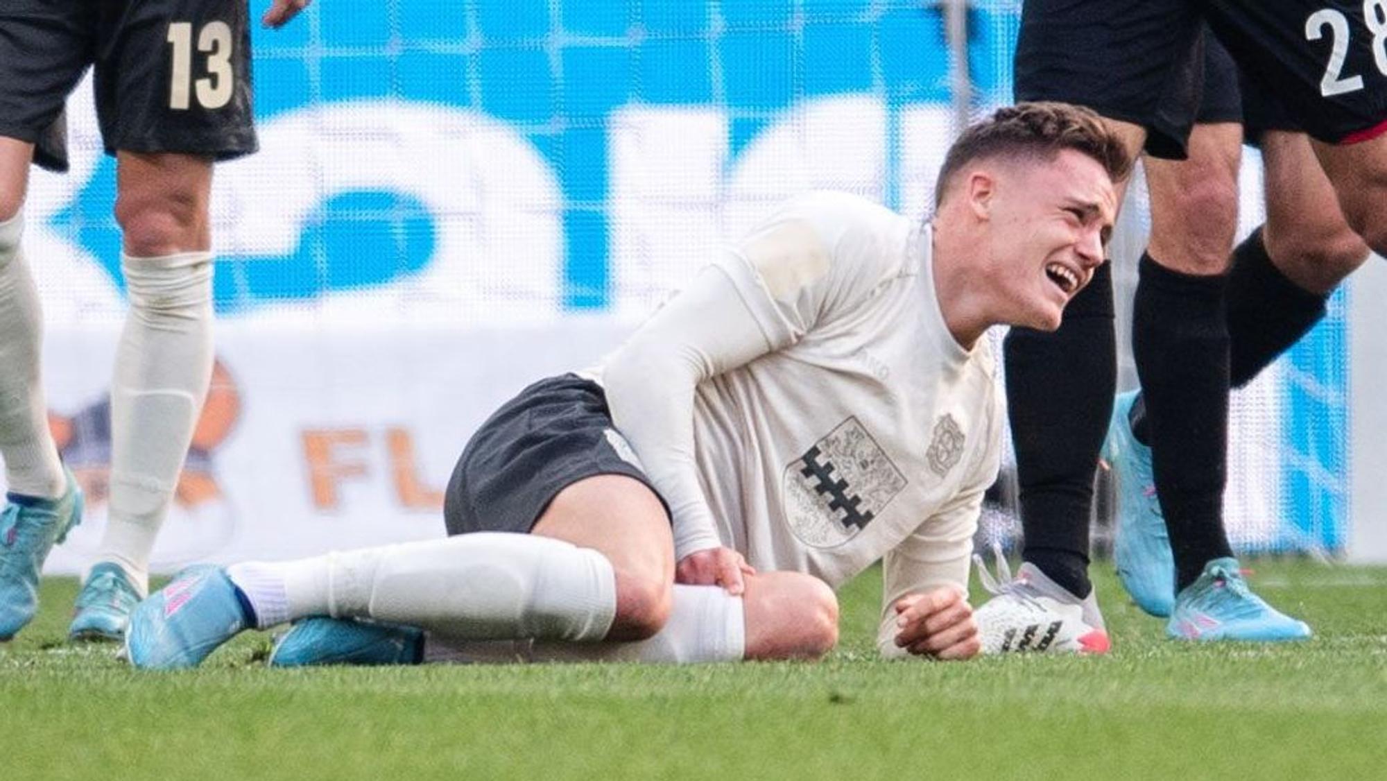 Leverkusens Florian Wirtz liegt verletzt am Boden.