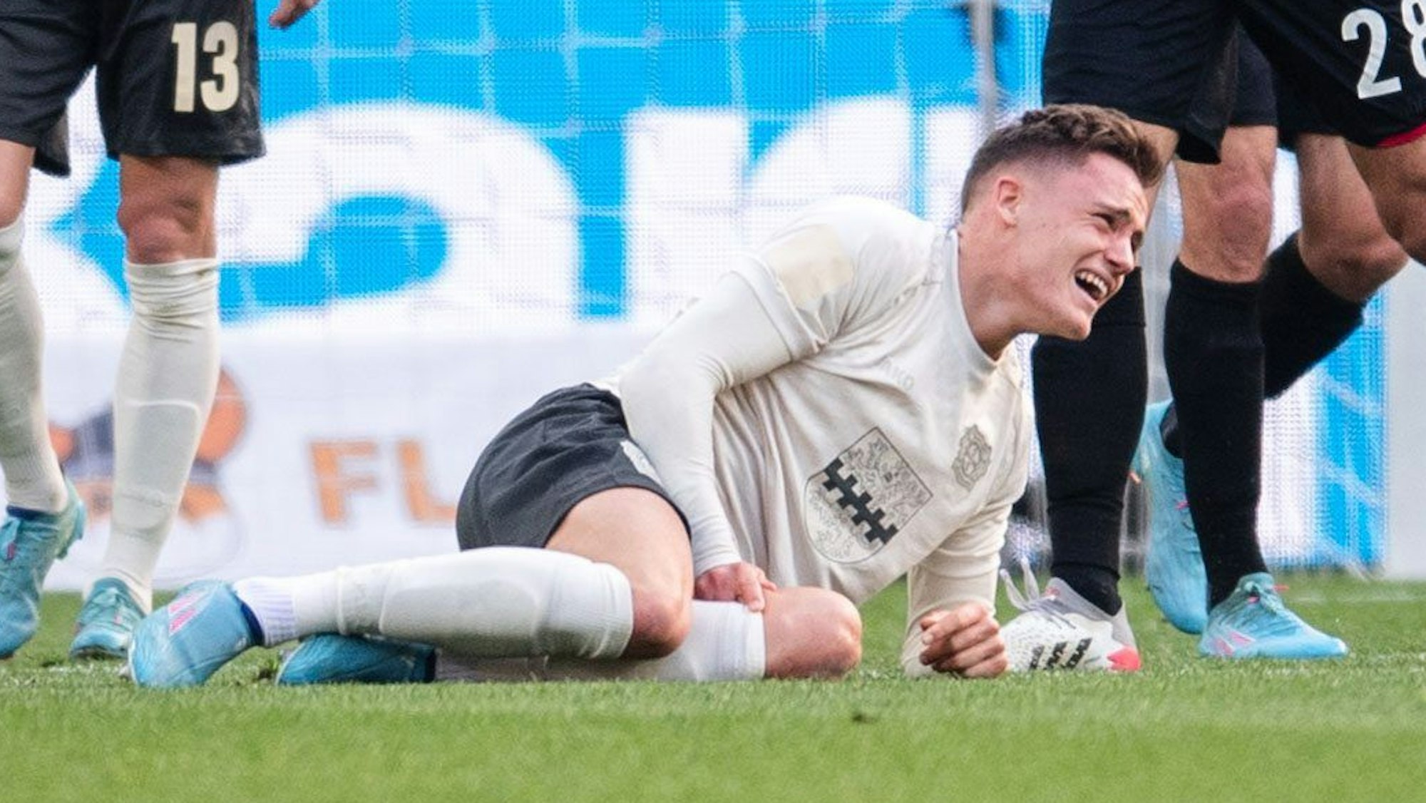 Leverkusens Florian Wirtz liegt verletzt am Boden.