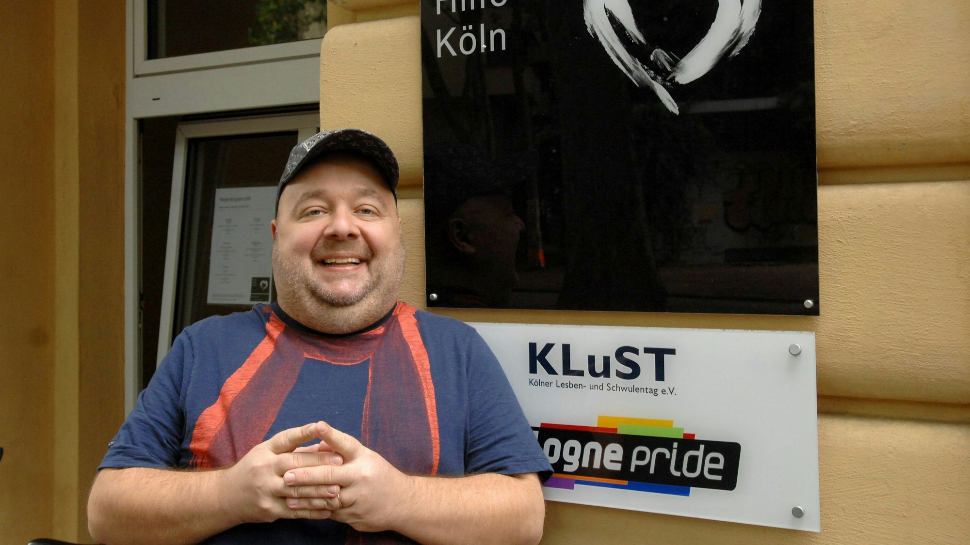 Dirk Bach vor dem Schild der Aidshilfe Köln.