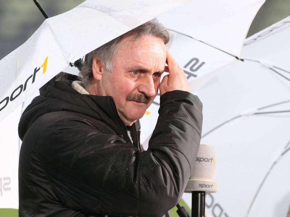 TV-Experte Peter Neururer mit Regenschirm im Stadion.