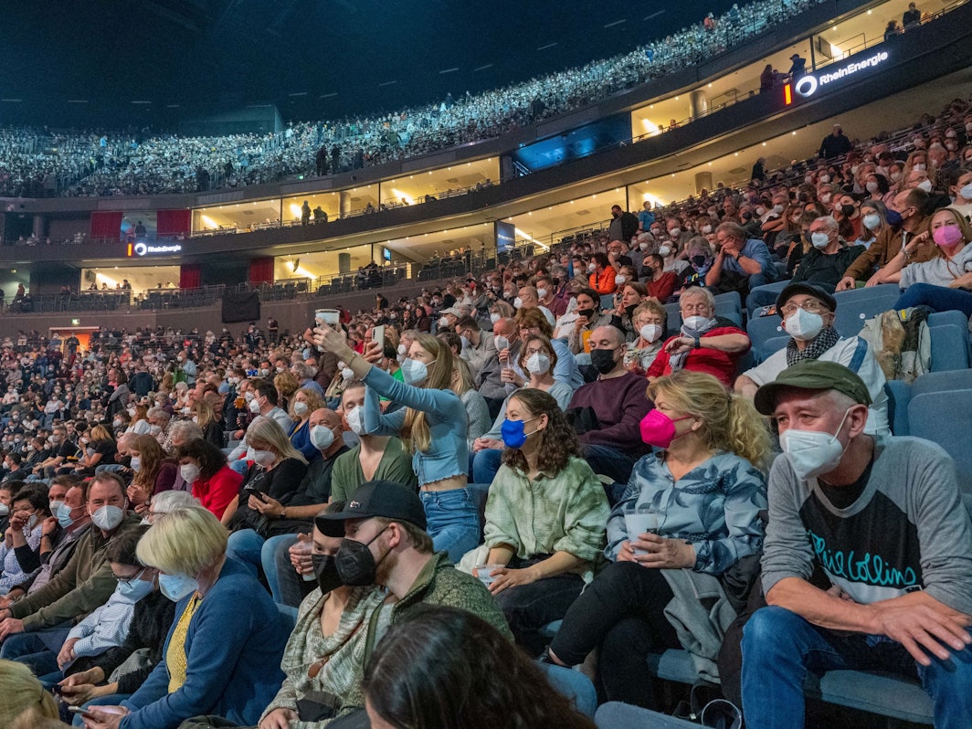 Zuschauer feiern beim Konzert von Genesis in der Lanxess-Arena.