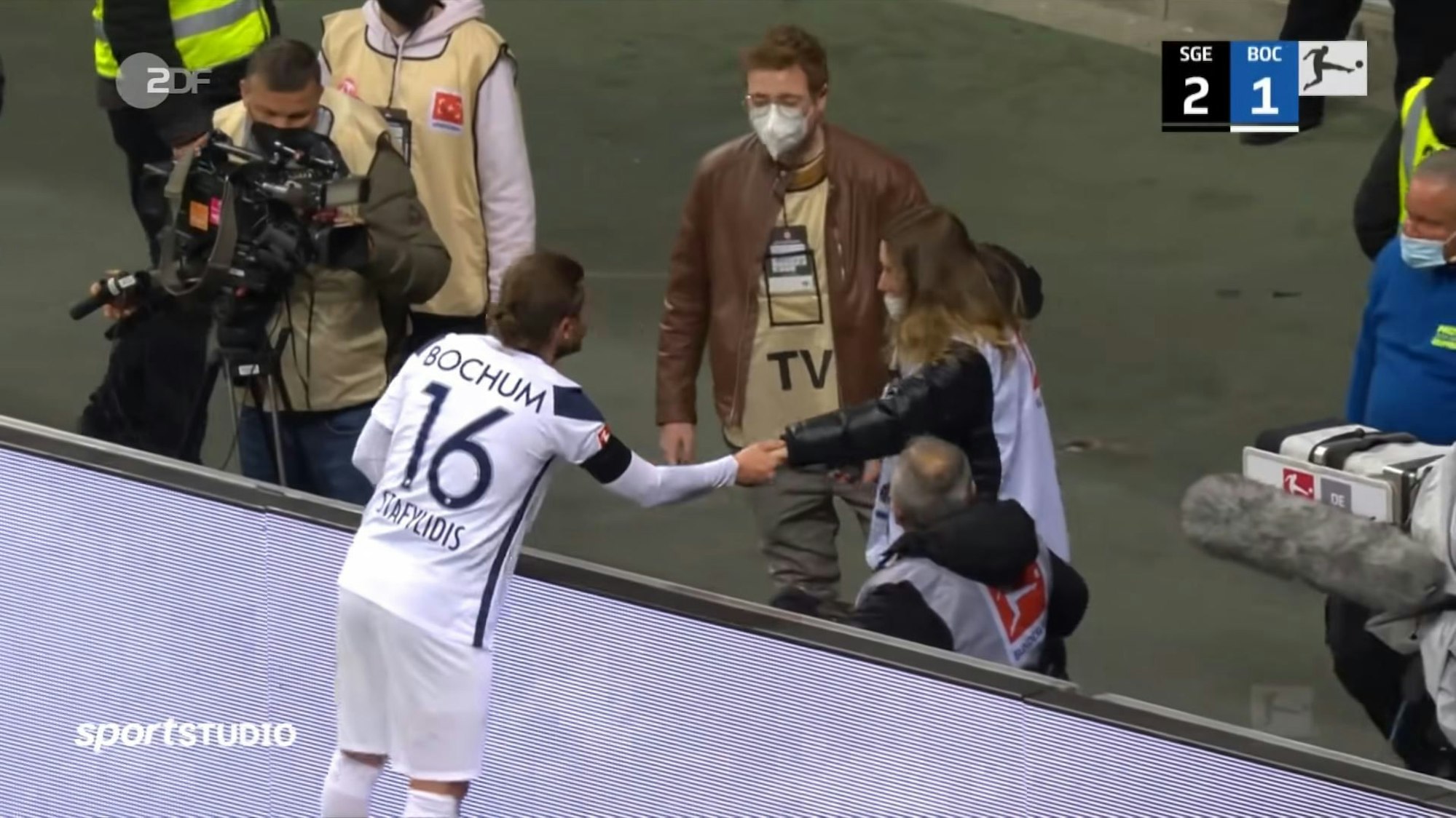 Konstantinos Stafylidis vom VfL Bochum entschuldigt sich nach dem Gesichts-Treffer bei Alina Friedrich, Mitarbeiterin von Eintracht-TV.