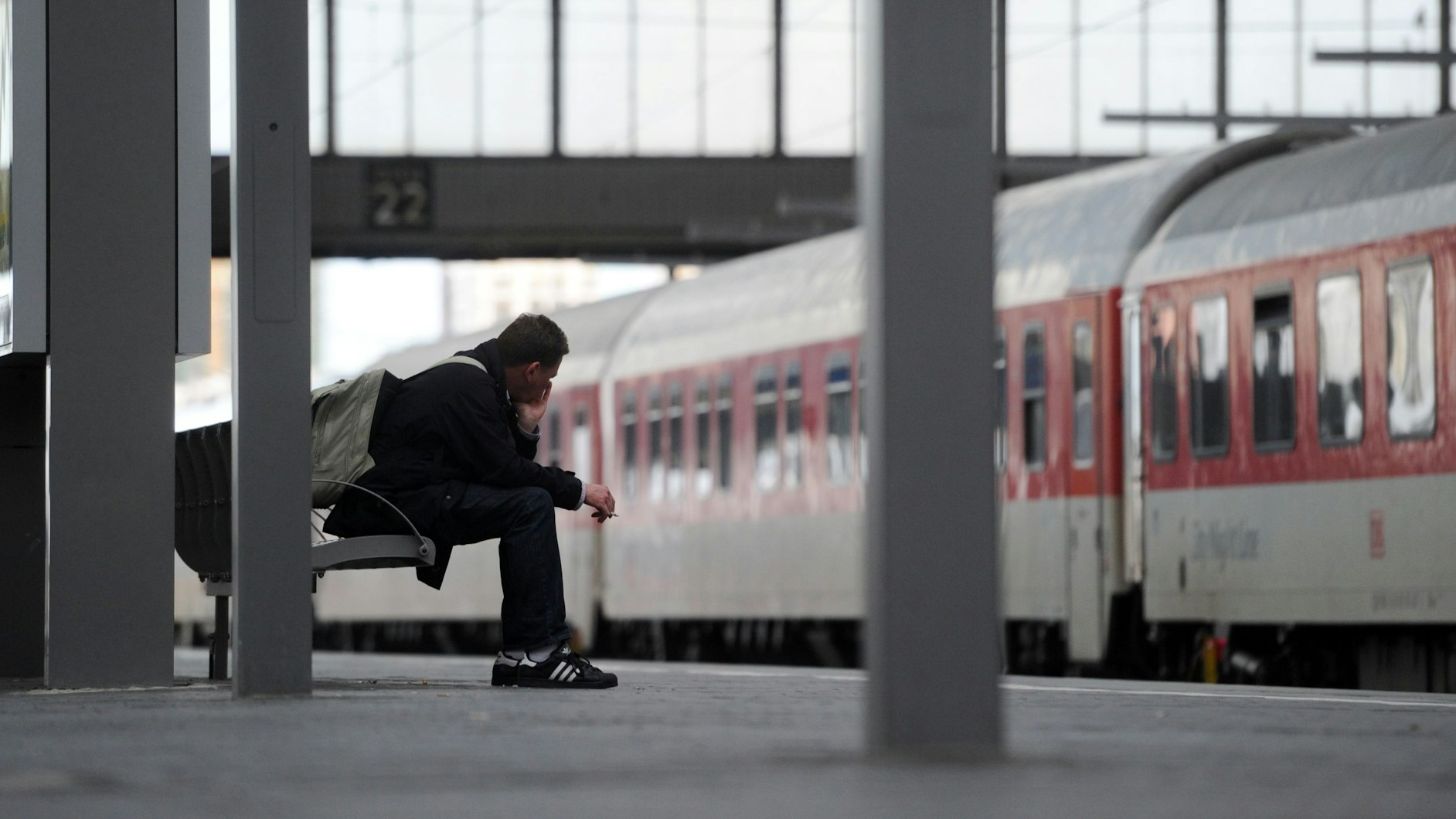 Ein Mann im Bahnhof auf einer Bank.