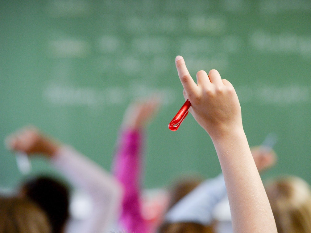 Eine Schülerin meldet sich in einem Klassenzimmer.