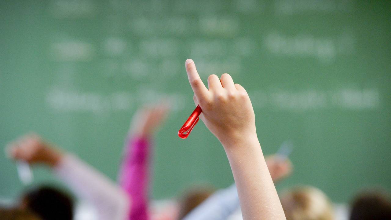 Eine Schülerin meldet sich in einem Klassenzimmer.