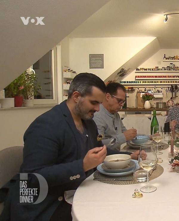 Das perfekte Dinner (Vox-Ausstrahlung 15.03.2022). Gastgeberin Amira sitzt am Kopfende des Tisches