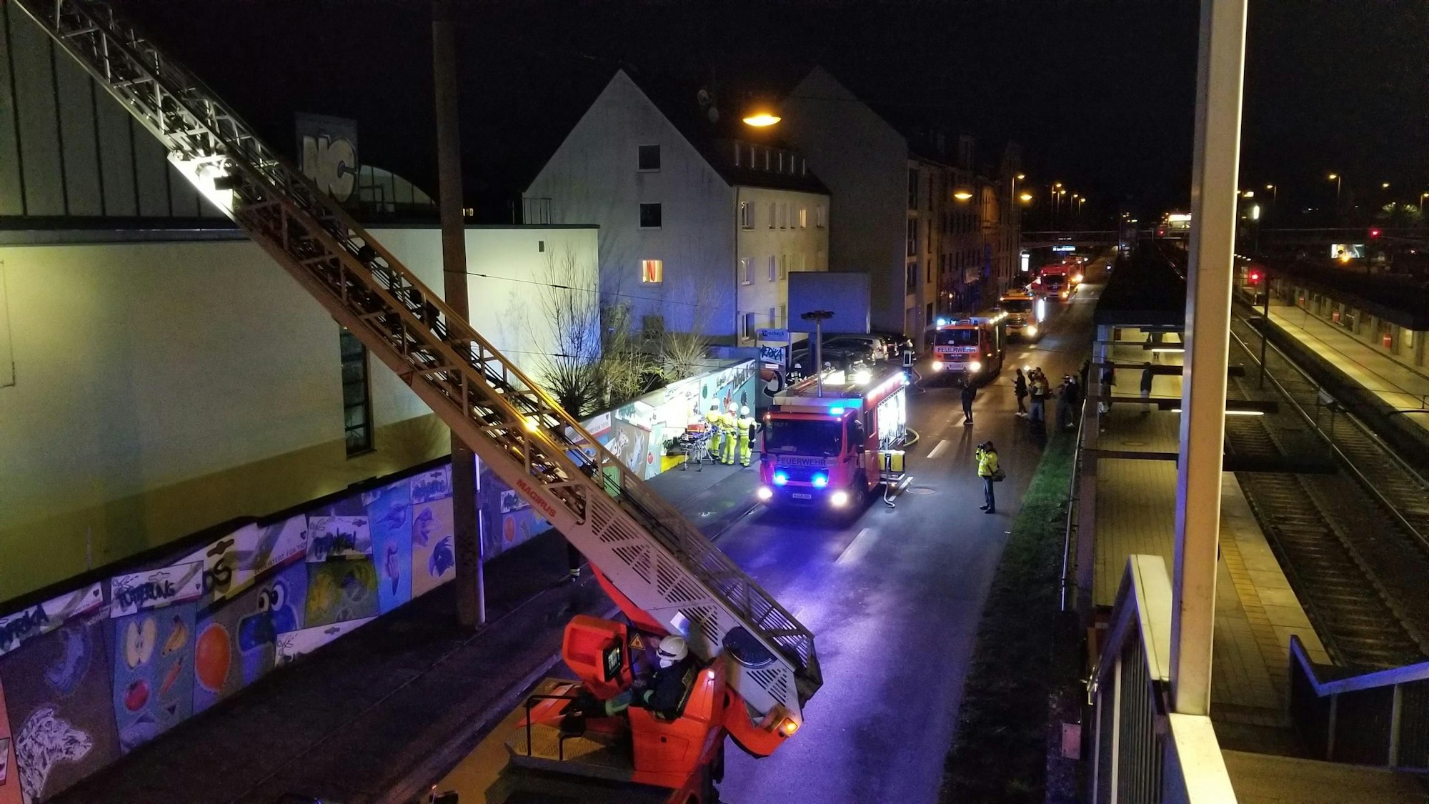 Die Kölner Feuerwehr rückte mit einem Großaufgebot an. Zu sehen ist der Leiterwagen und weitere Feuerwehrwagen, die an der Riehler Haltestelle Boltensternstraße stehen.